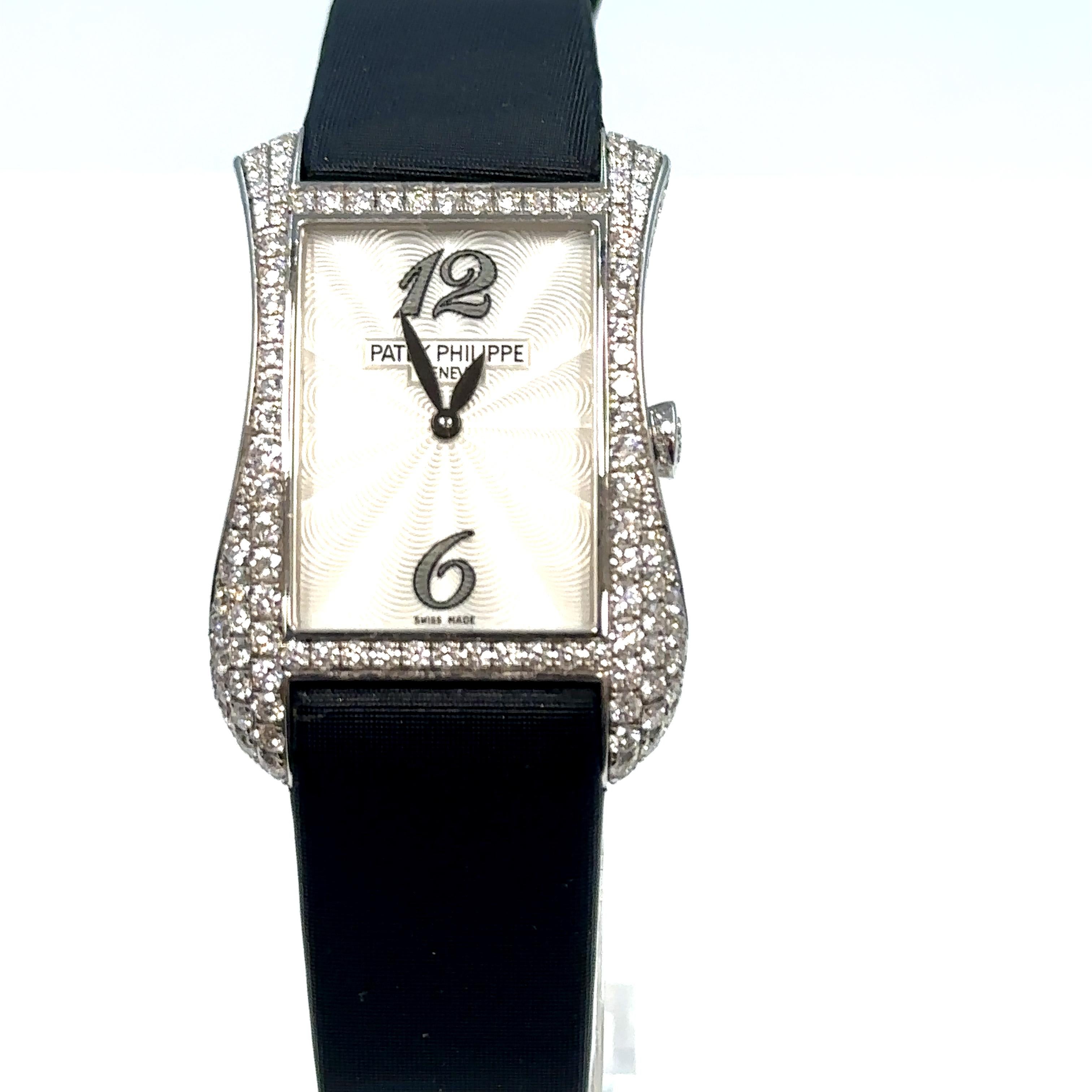 This is an absolutely stunning Patek Philippe Genovo Serata ladies watch Ref 4972G in excellent condition.

Solid 18kt white gold case, pave set with 243 diamonds weighing approximately 2.54 carats.

Black satin strap with white gold pin buckle set