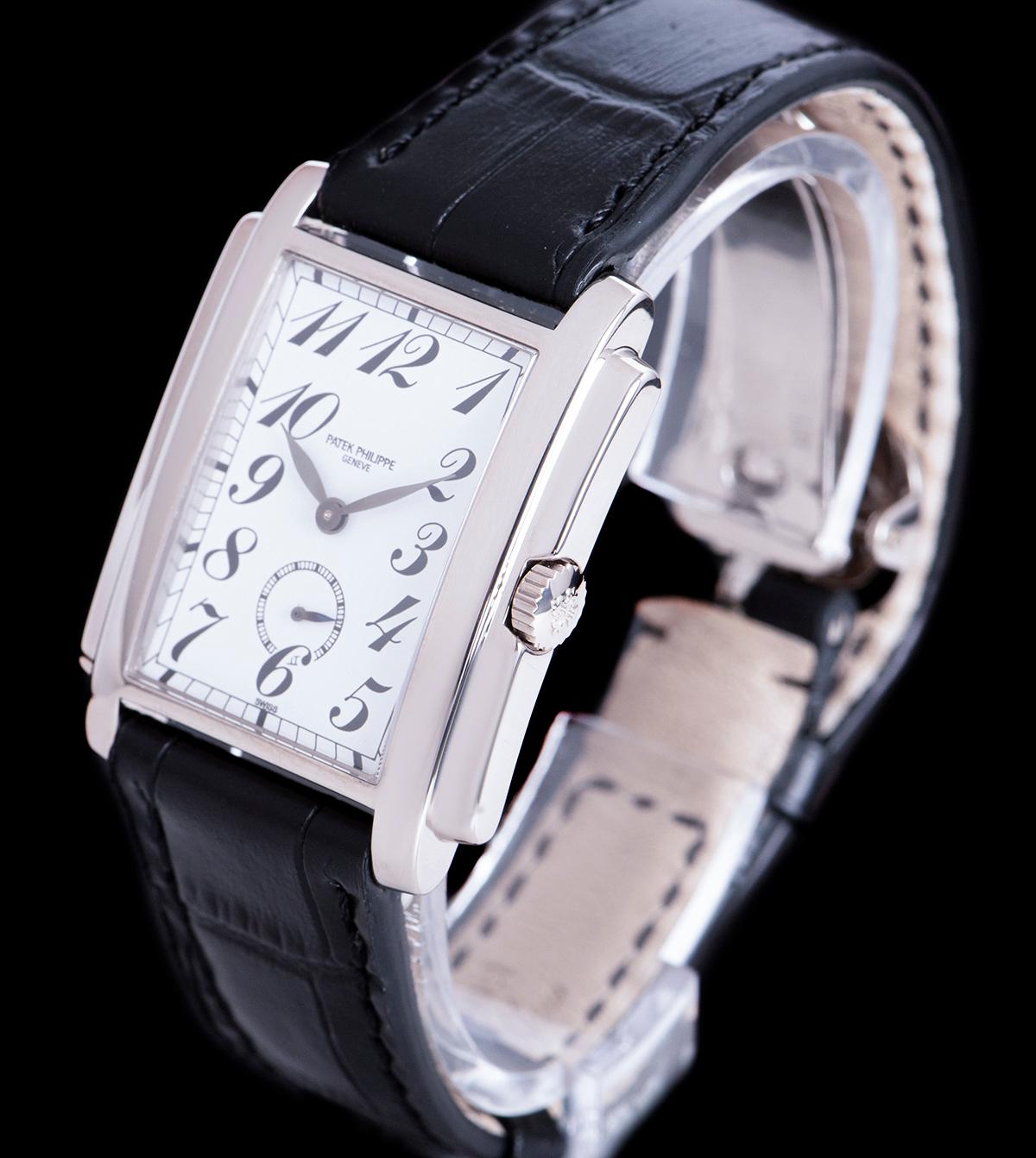 An 18k White Gold Gondolo Gents Wristwatch, white porcelain dial with arabic numbers, small seconds at 6 0'clock, a fixed 18k white gold bezel, a black leather strap (not by Patek Philippe) with an original 18k white gold deployant clasp, sapphire