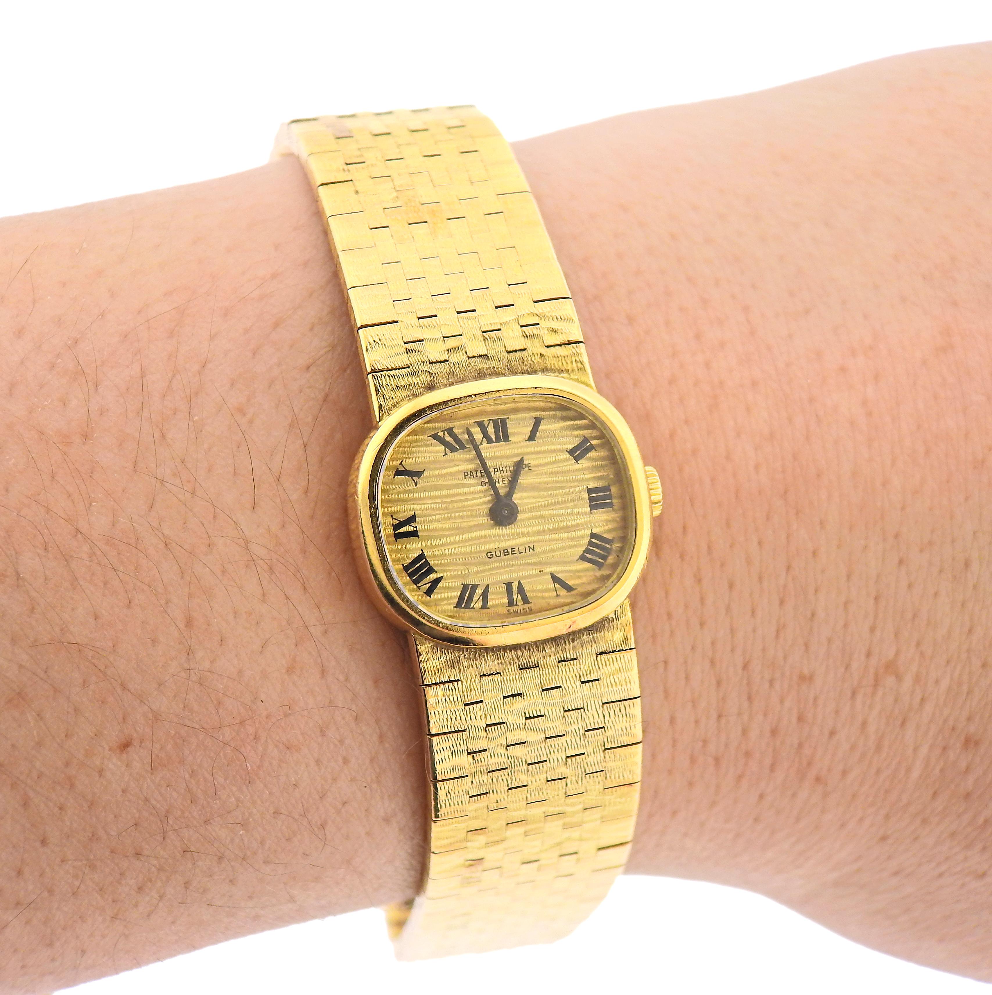 Vintage 18k gold Patek Philippe for Gubelin lady's watch. Case measures 20mm x 18mm, with gold ribbed dial, signed by Patek Philippe and Gubelin. Bracelet is 6