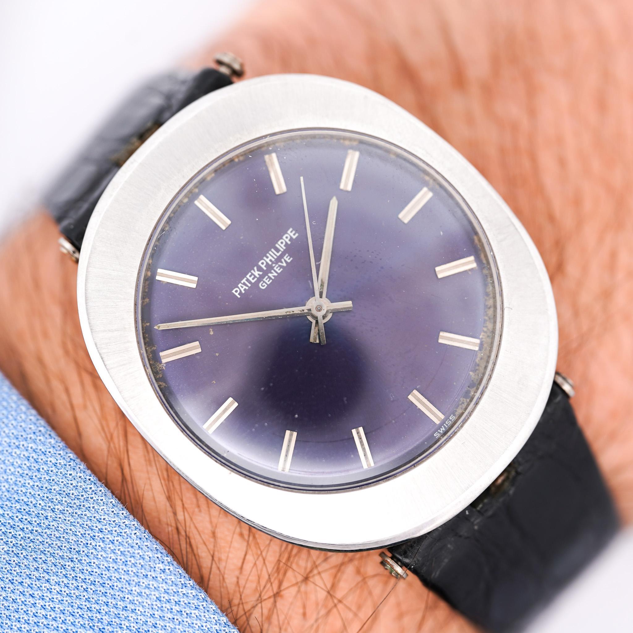 Unique Patek Philippe automatic watch in stainless steel featuring a cushion-shaped case measuring 35 x 40mm with metallic purple sunburst dial, stick hour markers, central sweep seconds, and automatic back-wind movement. Informally known as a