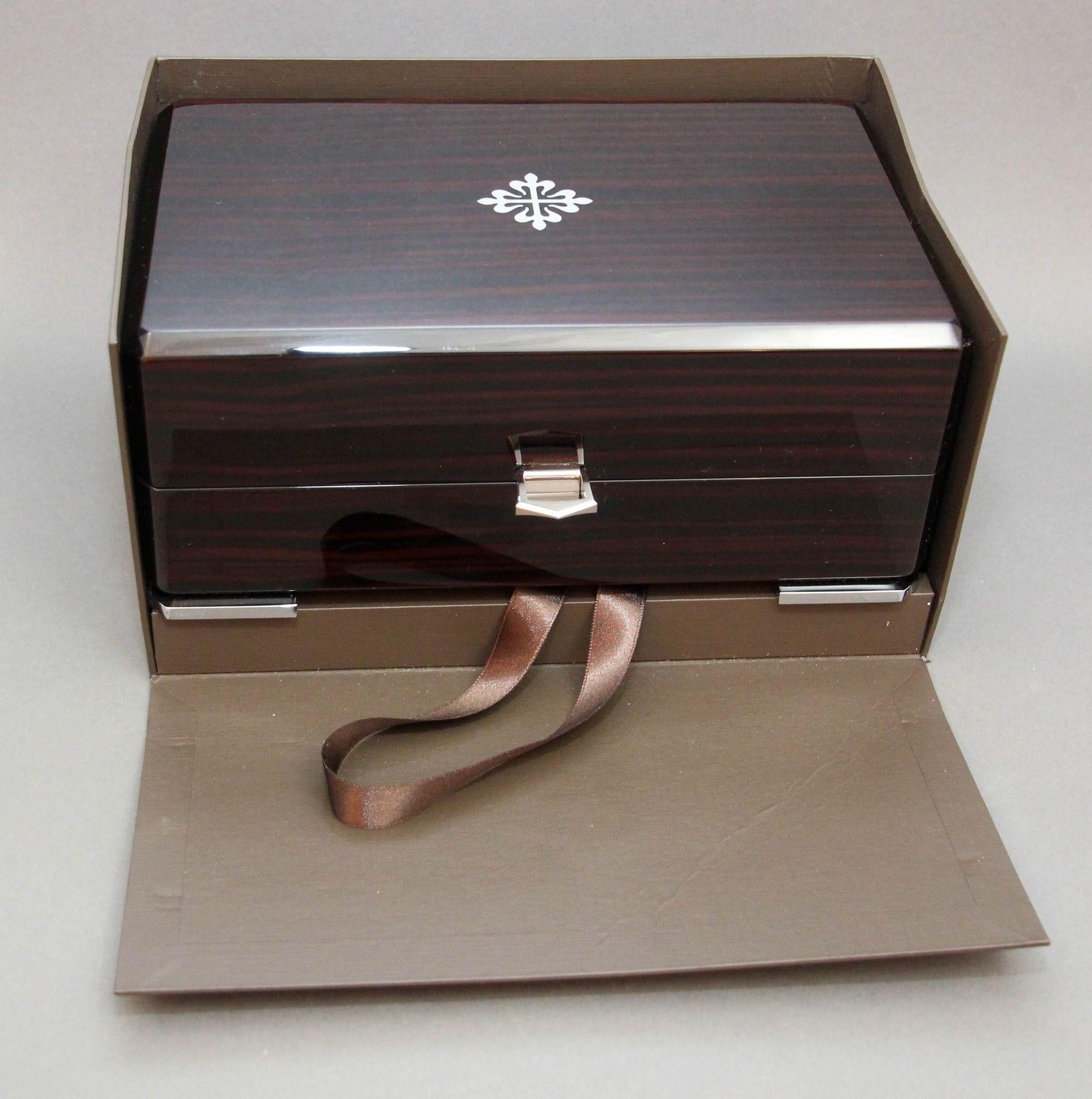 Patek Philippe lacquered wood Swiss watch Presentation Box.
It features a hinged front lock closure with metal hardware and an inlaid maker’s logo on the lid.
The interior is lined with beige soft leather and includes a watch insert.
The lid