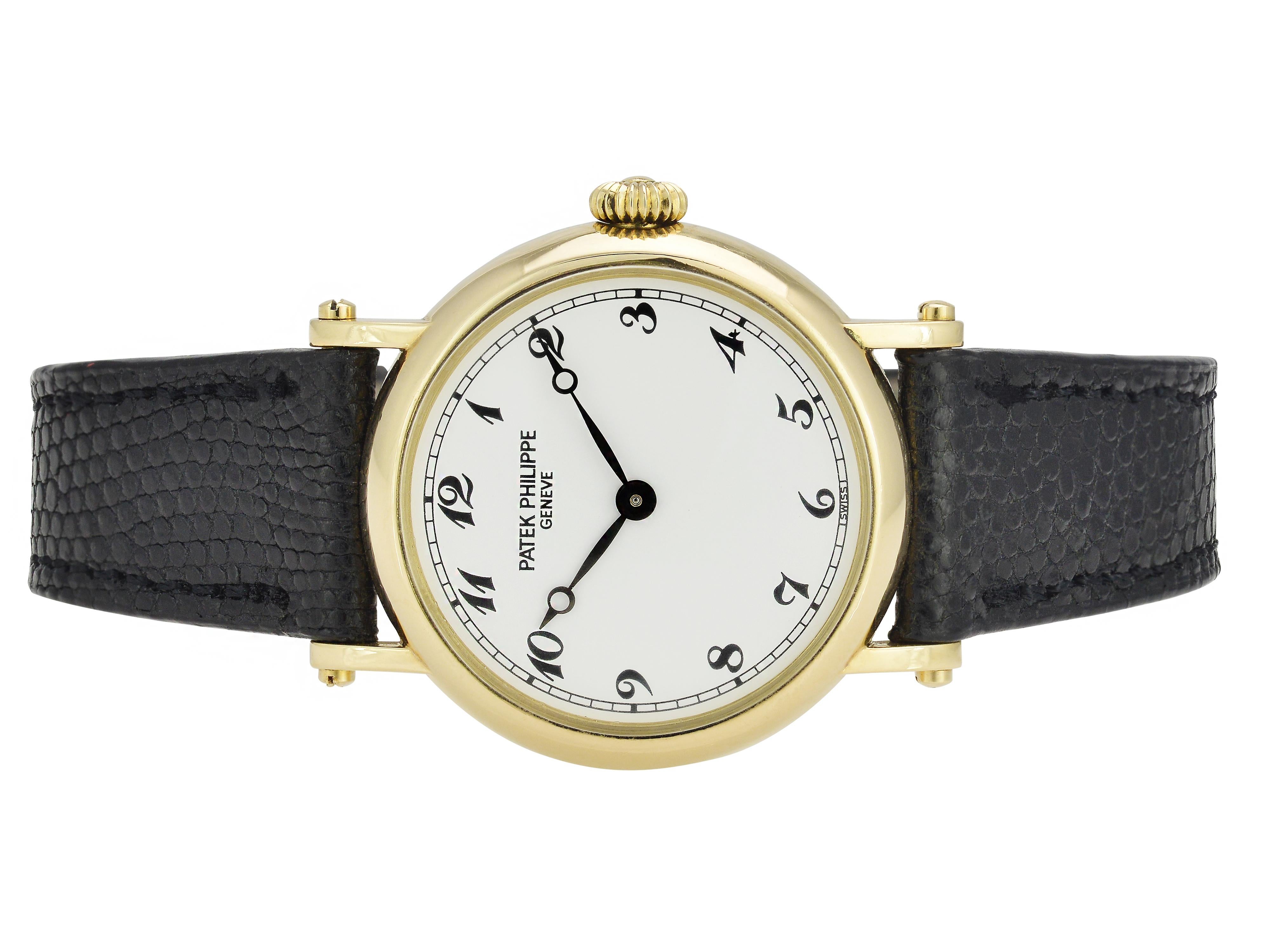 18 Karat Yellow Gold Patek Philippe Ladies Calatrava Wristwatch on Black Leather Strap.  Reference 4860 Manual Wind Movement. 26mm Case with White Dial and Arabic Numerals. 18 Karat Yellow Gold Tang Buckle. Includes 1 year warranty on timekeeping