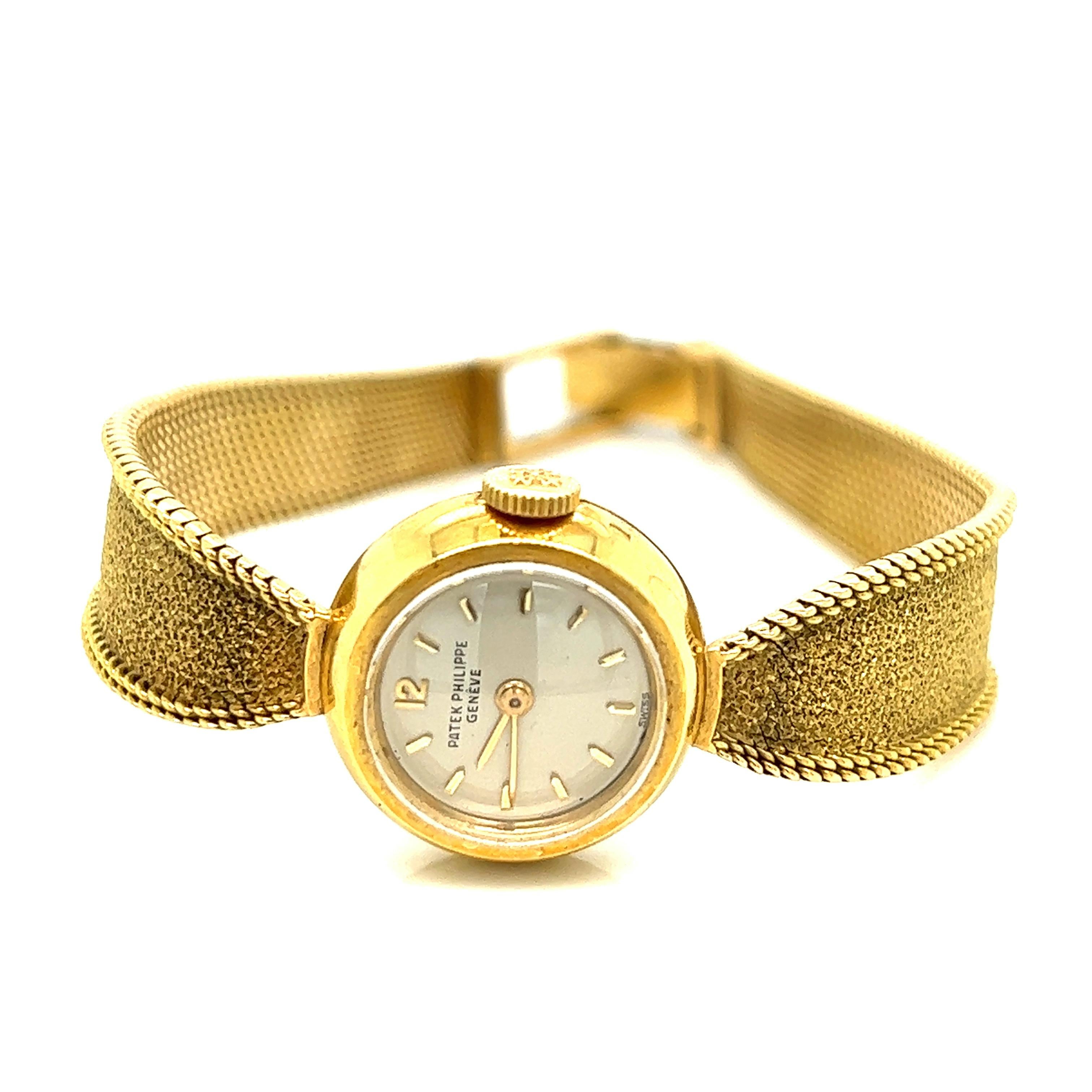 Patek Philippe lady's gold watch, Swiss

Mechanical manual wind movement, round case, silver dial with stick hour markers; integrated textured bracelet with gold over the clasp

Marked: Patek Philippe & Co., Geneve, 750, Swiss, Ref. 3006, 18