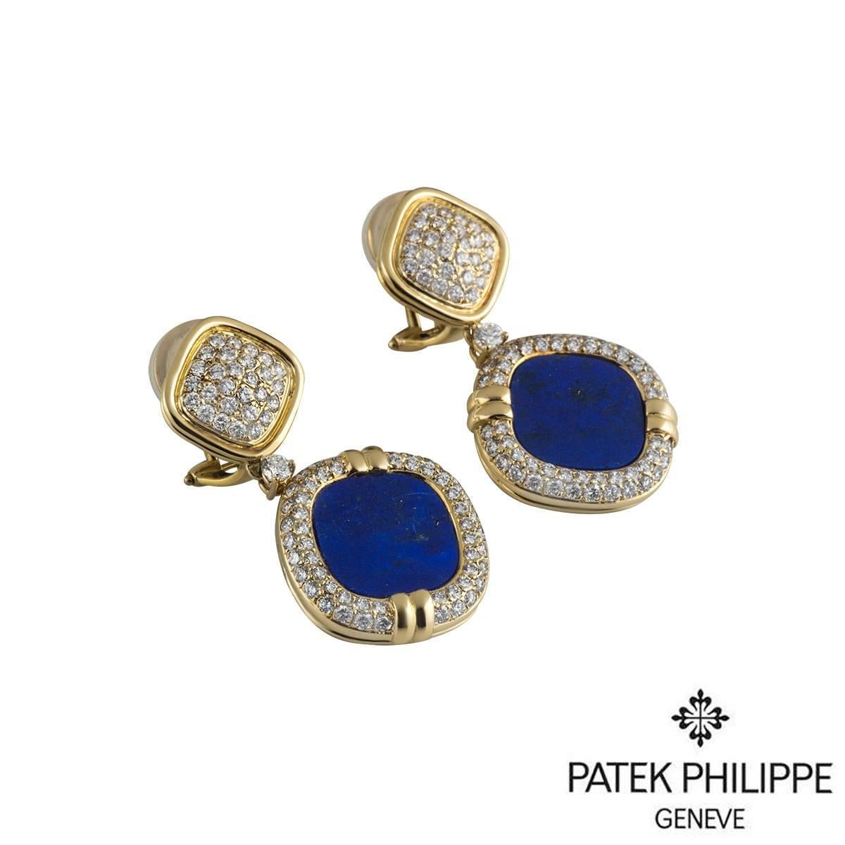 A stunning pair of rare 18k yellow gold Patek Philippe earrings. Each earring is composed of a pave round brilliant cut diamond set rhombus motif, suspending a single round brilliant cut diamond and a larger motif featuring a lapis lazuli stone with