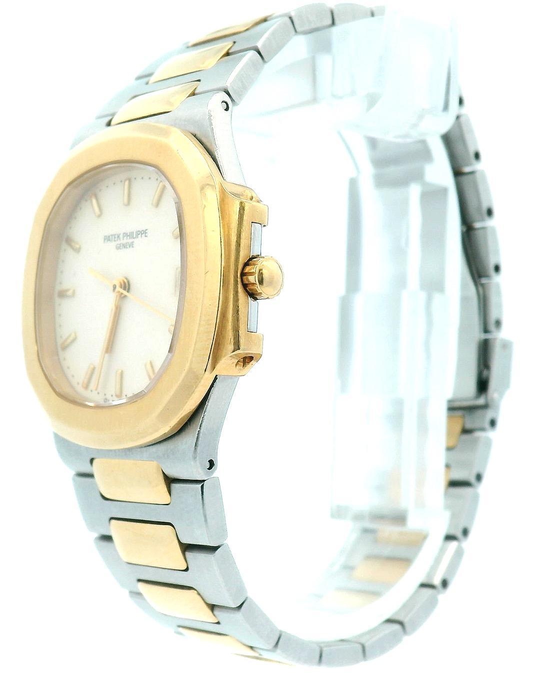 Patek Philippe Nautilus 3900/1JA Mens Watch. 33mm stainless steel case with 18K yellow gold smooth bezel. Ivory dial with gold hands and index hour marker. The date is displayed at 3 o'clock position. 18K yellow gold and stainless steel bracelet