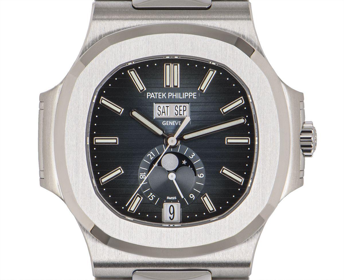 An unworn Nautilus in stainless steel by Patek Philippe. Featuring a new blue dial that shades to black which is exclusive to this steel model. The dial features the day, date and month as well as a moon phases display and 24-hour indicator. The