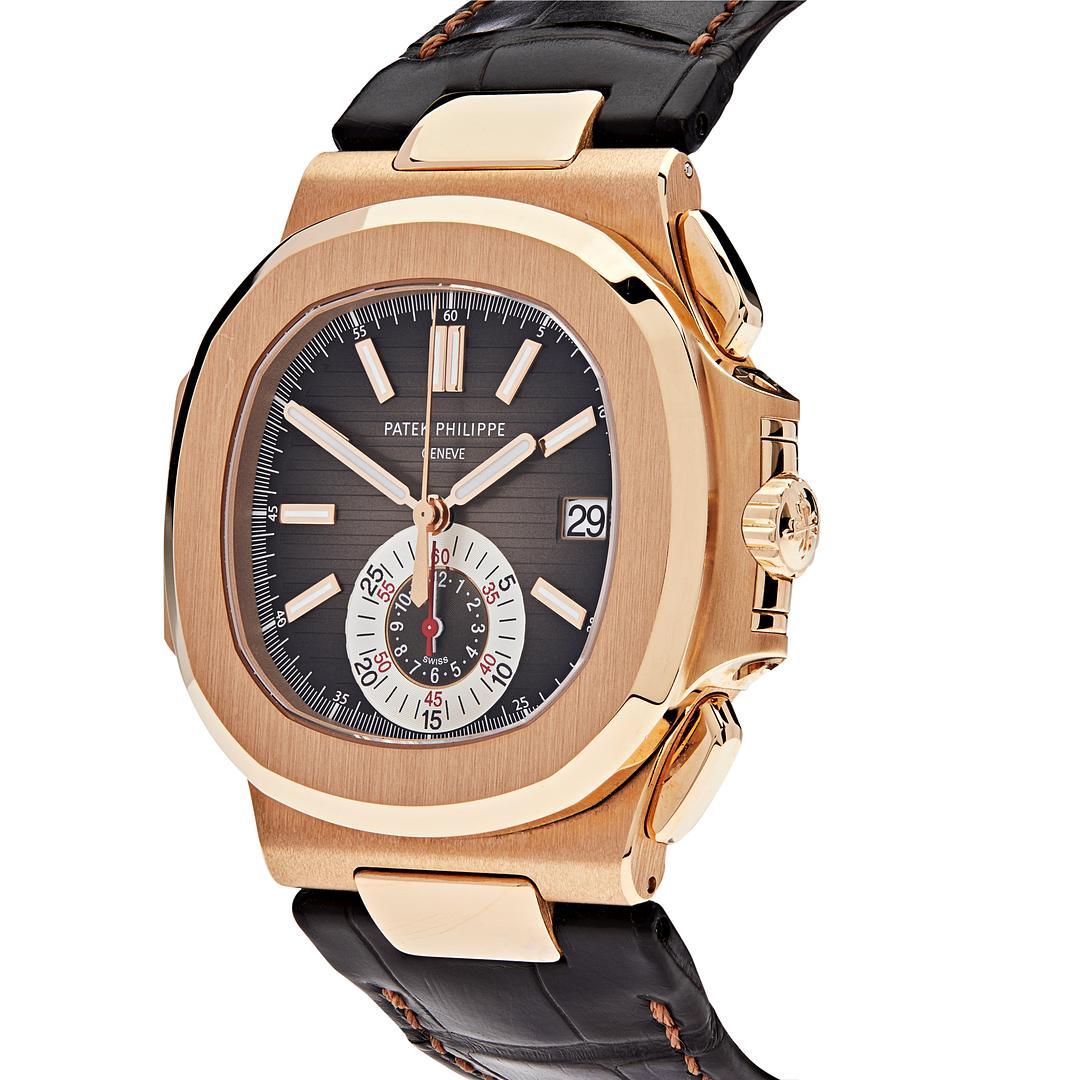The Patek Philippe Nautilus Chronograph Date features a 40.5mm rose gold case with a round octagonal shape and smooth satin-finished bezel. The brown dial is protected with a sapphire-crystal and finished with a brown alligator strap and fold-over