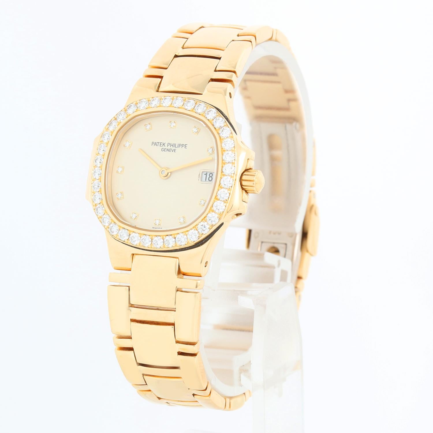 Patek Philippe Nautilus Ladies 18k Yellow Gold Diamond  Watch 4700/530J 001 - Quartz. 18k yellow gold with factory diamond bezel (26mm diameter). Ivory dial with factory diamond hour markers; date at 3 o'clock position. 18k yellow gold Nautilus