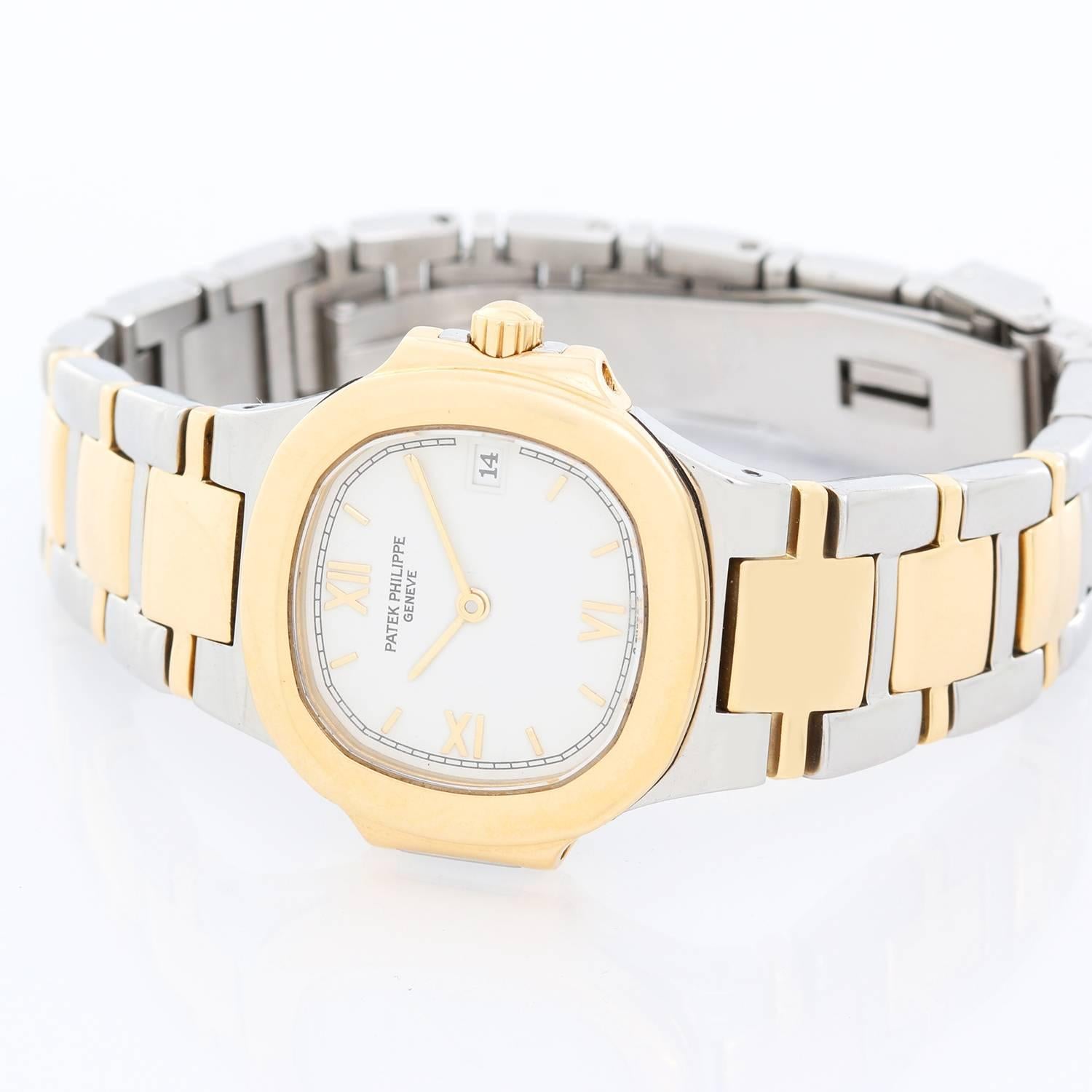 Patek Philippe Nautilus Ladies Steel Gold 2-Tone  Watch  4700/51 -  Quartz. Stainless steel case with 18k yellow gold bezel (26mm diameter). Ivory colored dial with Roman numerals and stick markers; date at 3 o'clock position. Stainless steel and