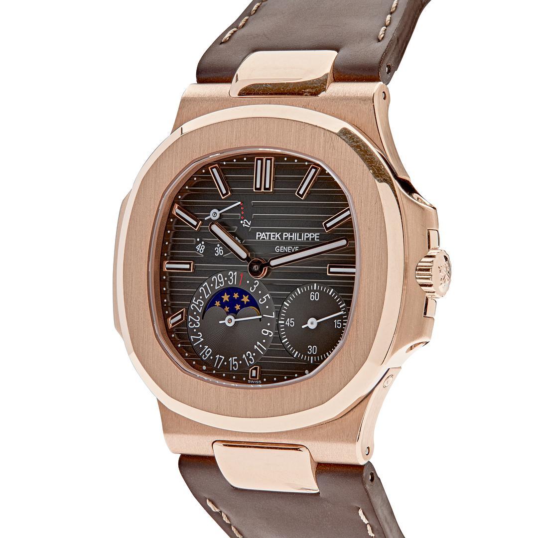 This Patek Philippe Nautilus timepiece features a 40mm 18k rose gold case surrounding an embossed brown dial with luminous hours and hands. It is finished on a brown alligator strap and fold-over clasp.


Reference