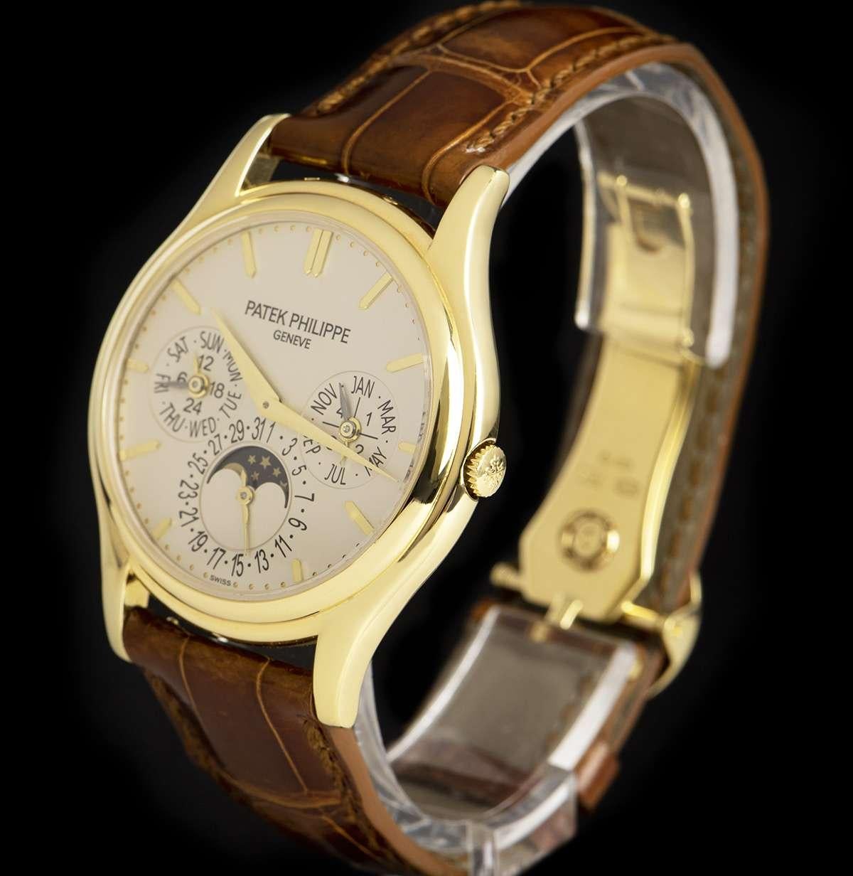 An 18k Yellow Gold Perpetual Calendar Gents Wristwatch, silver dial with applied hour markers, month and leap year sub-dial at 3 0'clock, moonphase display and date at 6 0'clock, week day and 24 hour sub-dial at 9 0'clock, a fixed 18k yellow gold