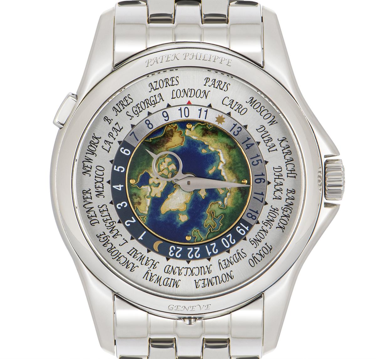 A 39.5 mm platinum World Time with complications by Patek Philippe. Featuring a silver dial with a cloisonne enamel centre. The dial itself features a 24-hour display and the time of 24 worldwide locations. Set just beneath the case at 6 o'clock is