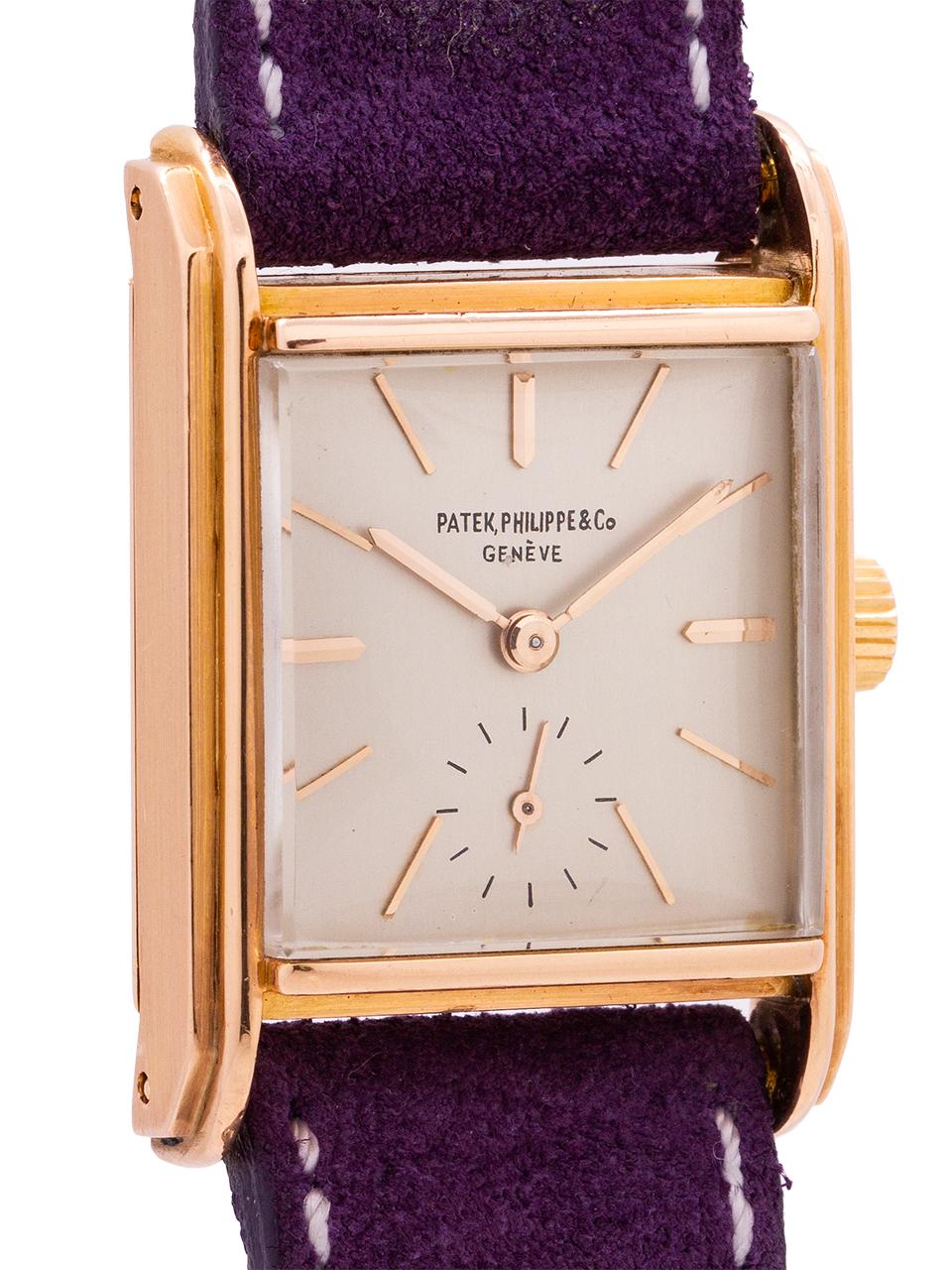 
A very attractive vintage Patek 18K rose gold rectangle case dress model circa 1946. With a nicely proportioned, thick 26 x 37mm case with raised stepped bezel and extended lugs. Silver satin dial, applied pink indexes and pink baton hands. The