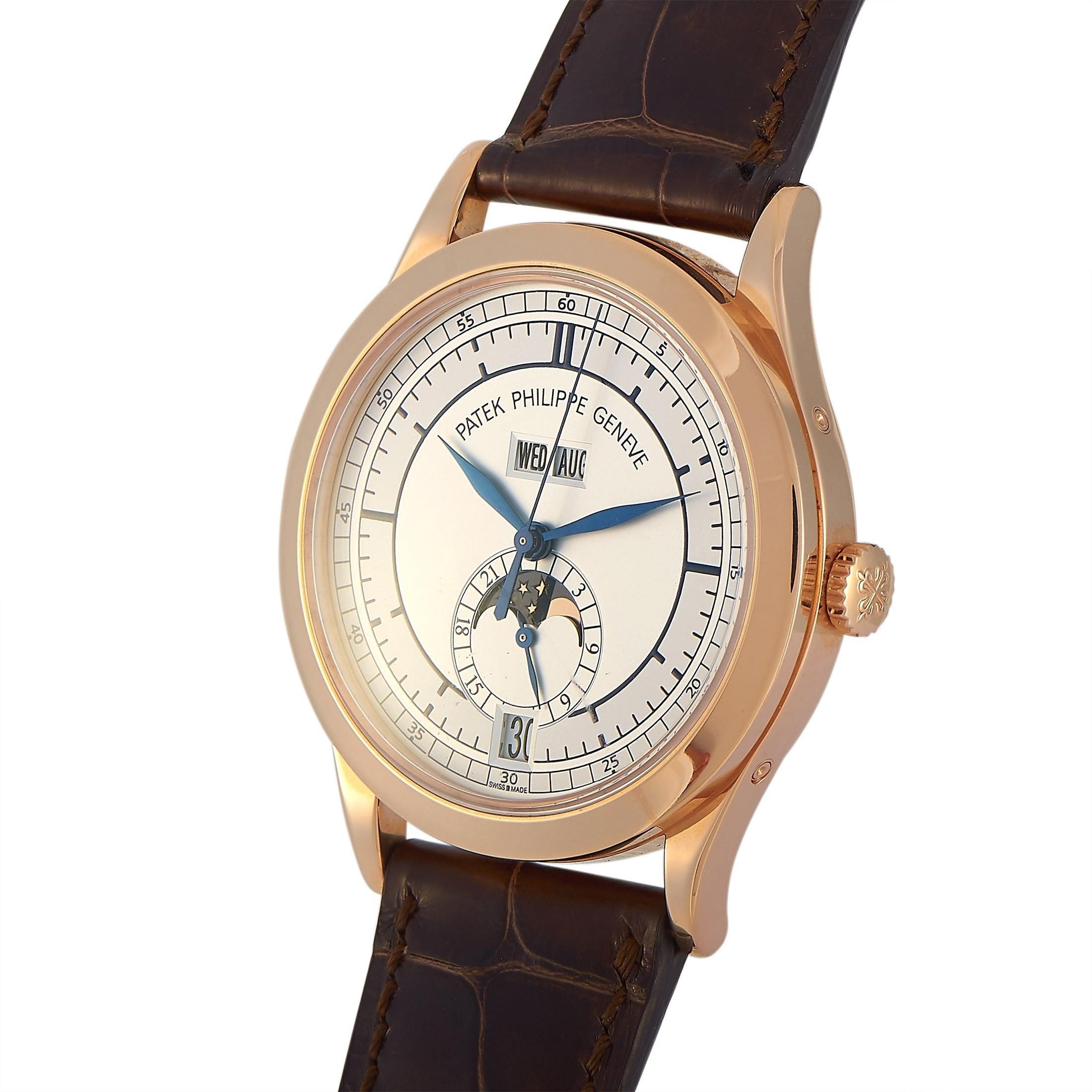 This luxury watch is defined by its elegant simplicity. On its two-toned silvered dial are blue painted index hours, minutes, and seconds markers. Matching gunmetal blue hands point to time. Positioned beneath 12 o'clock is the annual calendar