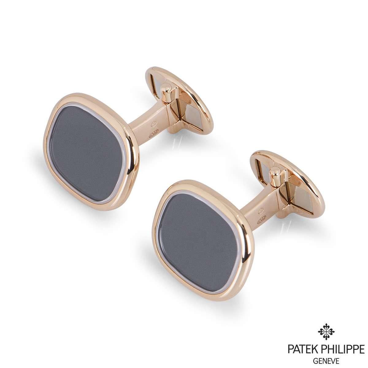 A pair of 18k rose gold Ellipse cufflinks by Patek Philippe. Each cufflink is set to the front with an ebony black sunburst dial with a polished rose gold surround, measuring 14mm in height and 16mm in width. The cufflinks have T-bar fittings and