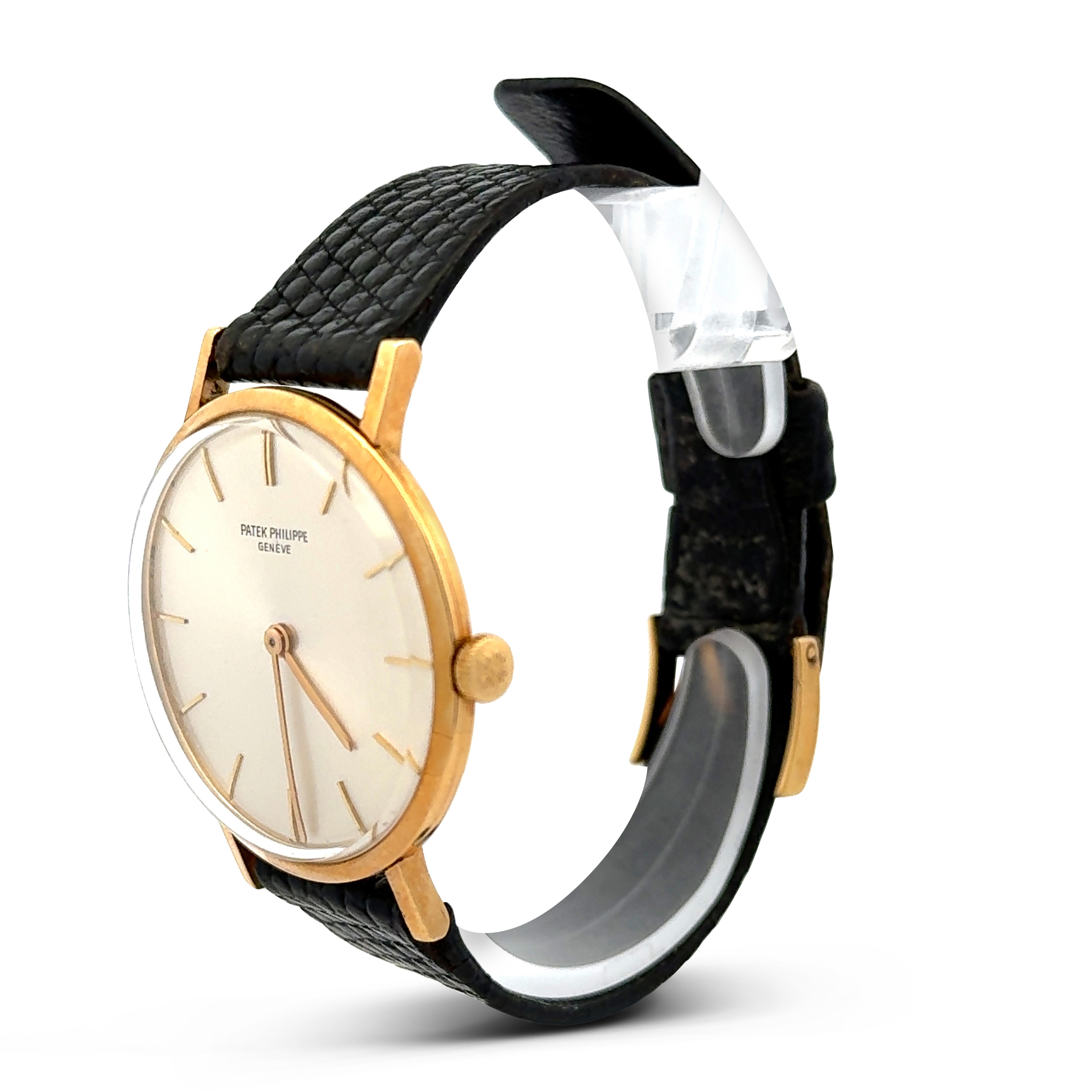 A classic Patek Philippe wristwatch, featuring a round dial covered in crystal. Hours and hands are represented by yellow gold lines. Case and case back are made of 18K yellow gold. Straps are made of genuine black leather. Case size is 33 mm.