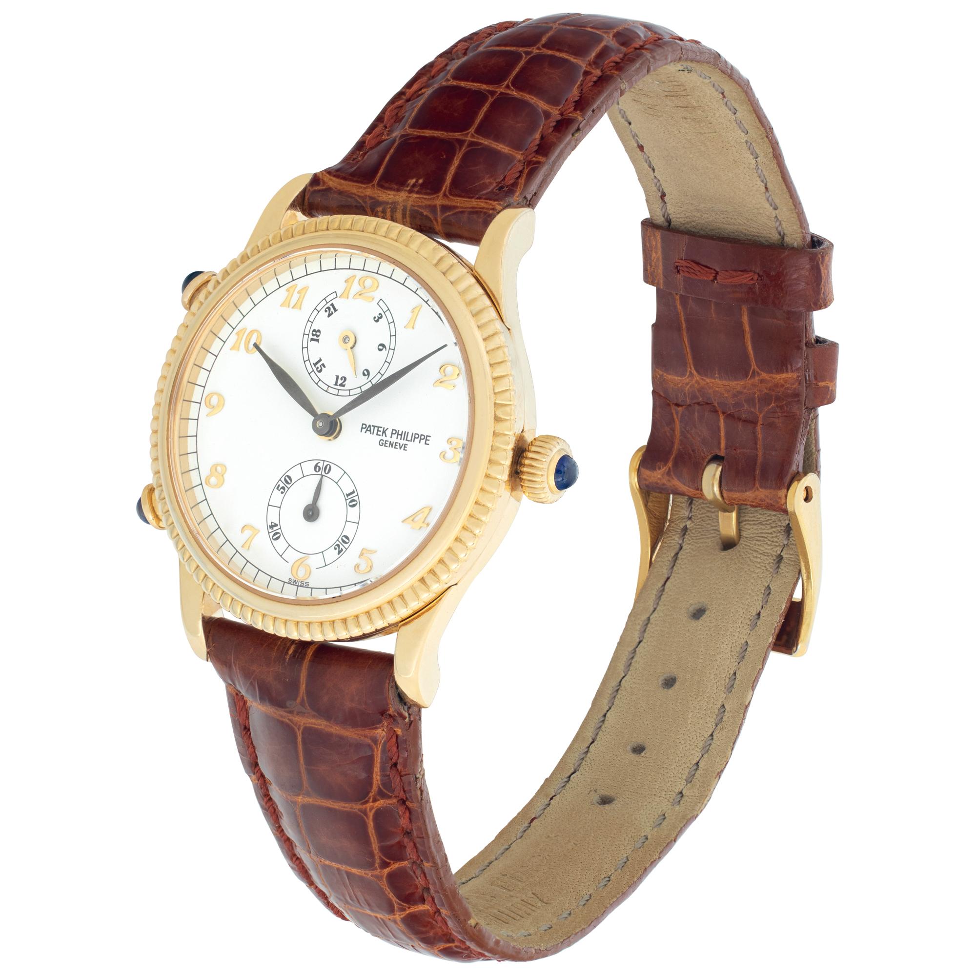 Patek Philippe Travel Time in 18k yellow gold a brown crocodile strap with 18k PP tang buckle. Manual wind 18 jewel movement with dual time zone, 24 hour indicator and sub-seconds. 29.5 mm case size. Ref 4864j. Fine Pre-owned Patek Philippe Watch.

