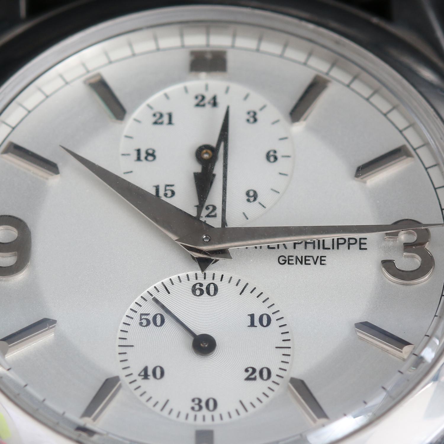 Patek Philippe Travel Time Men's 18k White Gold Watch 5134 G - Manual winding; dual time. 18k white gold case with exposition back (36mm diameter). Featuring the most recent 2-tone silver dial with white gold markers and Arabic numerals. Black strap