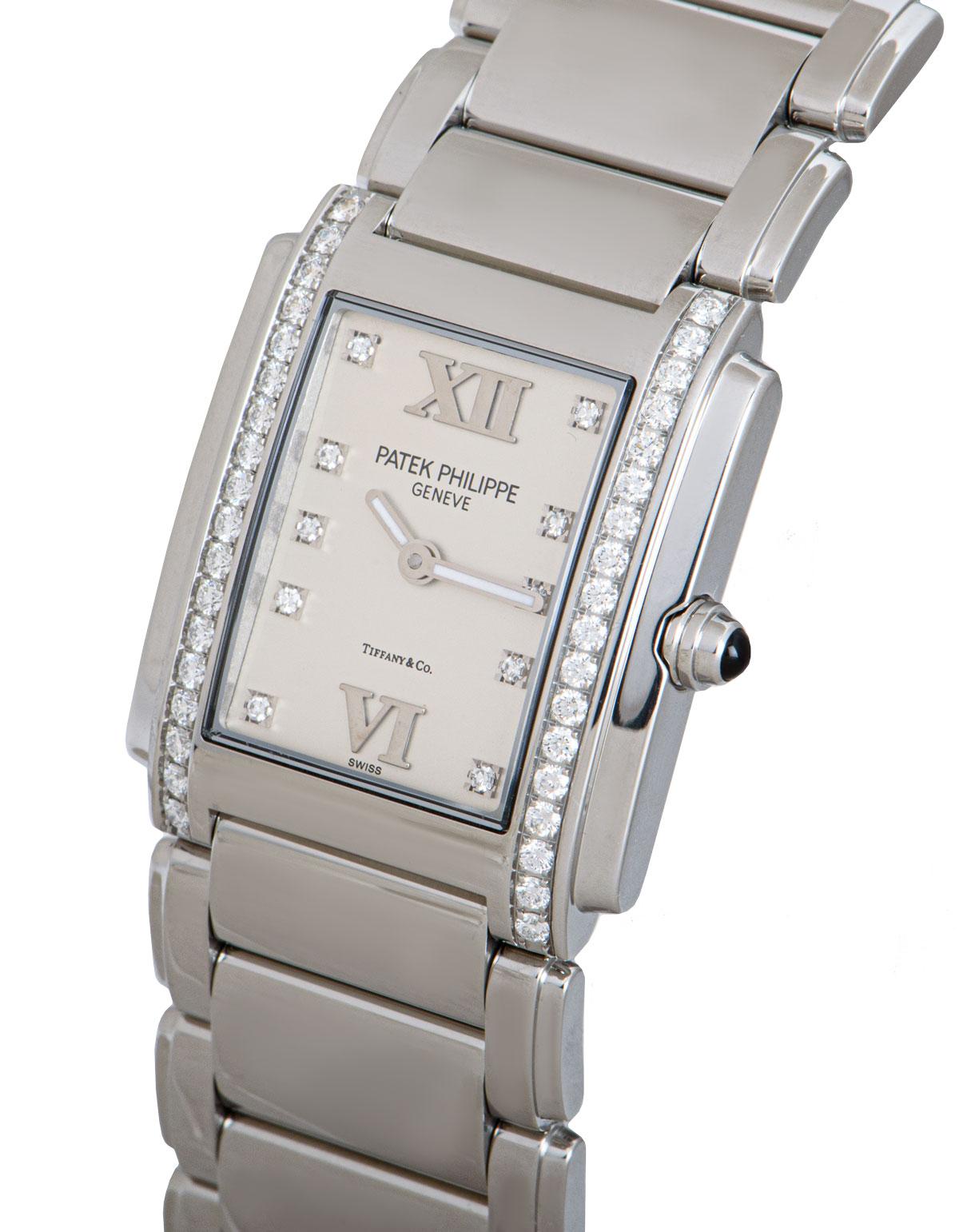 A 25 mm Stainless Steel Twenty~4 Ladies Wristwatch, double name Tiffany & Co. silver dial set with 10 applied round brilliant cut diamond hour markers and applied roman numerals VI and XII, a fixed stainless steel bezel set with 36 round brilliant