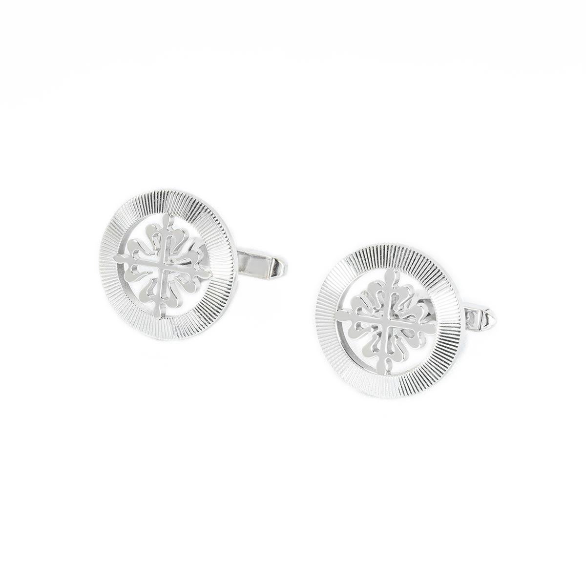 Coppia di gemelli Calatrava in oro bianco 18 carati di Patek Philippe. I gemelli presentano la classica decorazione a croce di Calatrava, circondata da un anello esterno guilloché. Ogni gemello è dotato di una barra a T e il motivo misura 18 mm di