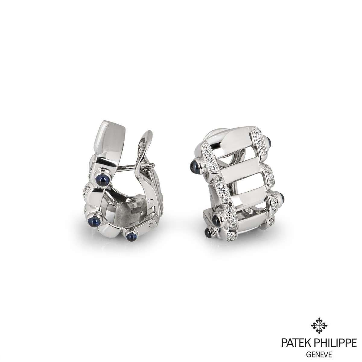 A pair of 18k white gold diamond earrings from the Twenty-4 collection by Patek Philippe. The earrings feature 60 round brilliant cut diamonds with a total weight of approximately 0.43ct. Set to the sides of the earrings are 12 cabochon blue