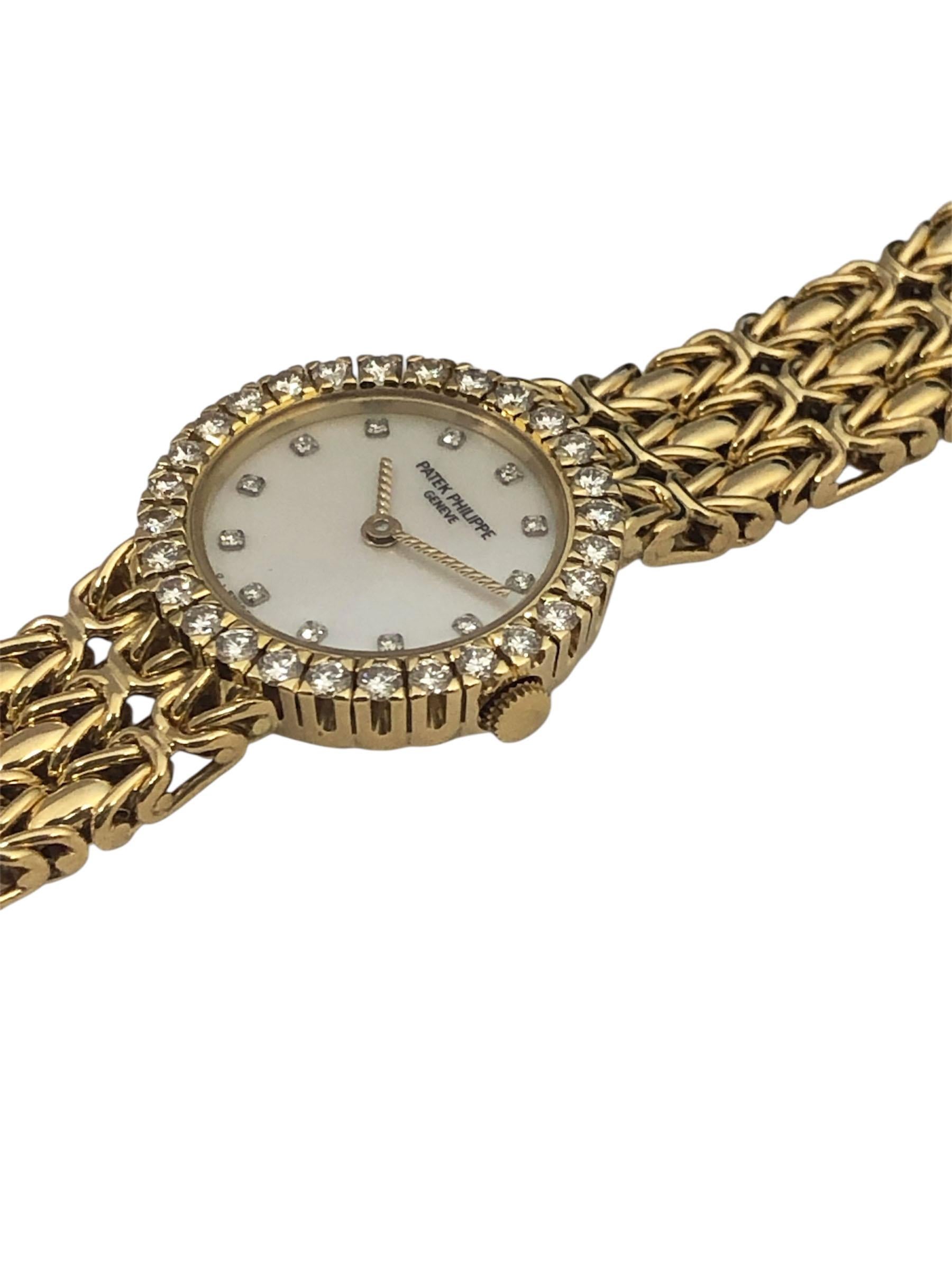Circa 1990 Patek Philippe Reference 4506/1 Ladies Wrist Watch, 21 M.M. 18k Yellow Gold 2 piece case with Diamond Bezel of fine White Round Brilliant cuts totaling just under 1 carat. Mouvement à quartz, cadran en nacre avec index sertis de diamants.