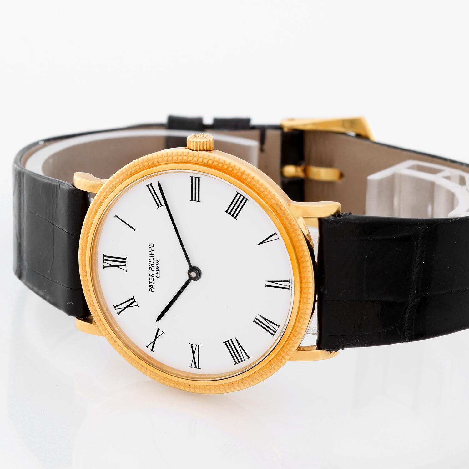 Patek Philippe Yellow Gold Calatrava Men's Quartz Watch Ref. 3954 J (or 3954J) - Quartz. 18k yellow gold case with hobnail bezel (33mm diameter). White dial with black Roman numerals. Black strap band with 18k yellow gold-tone buckle. Pre-owned with