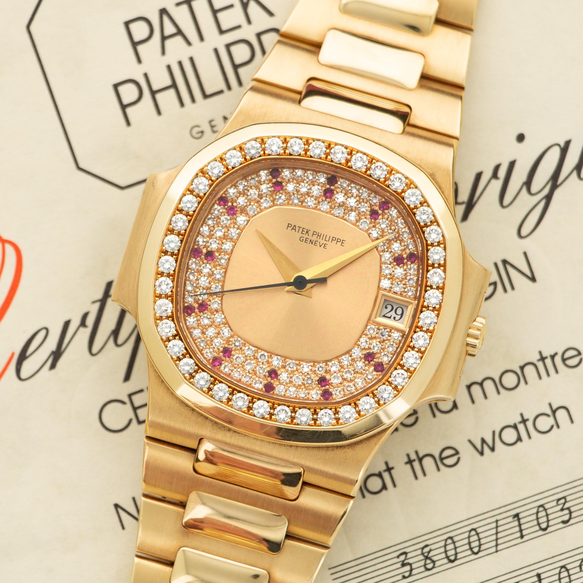 An 18k Yellow Gold Nautilus Watch by Patek Philippe. Original Pave Diamond Dial and Bezel with Ruby Markers. Accompanied by its Original Box and Paperwork. 