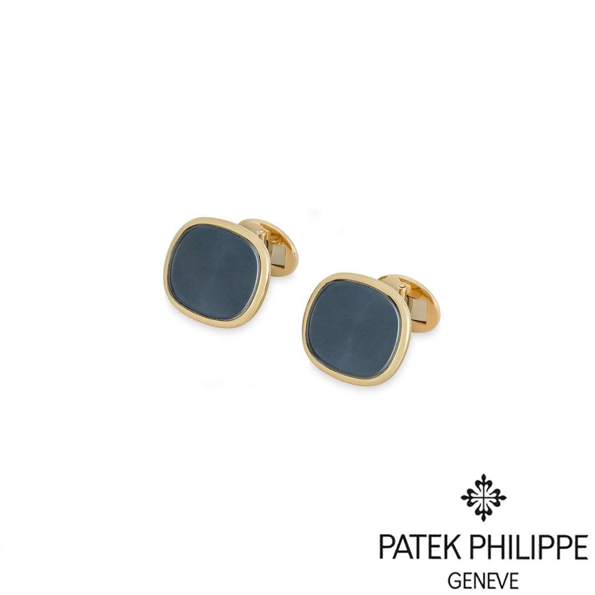 A pair of 18k yellow gold large Ellipse cufflinks by Patek Philippe. Each cufflink is set with a sunburst blue panel surrounded by a high polish border. The cufflinks measure 2.2cm in width, 1.9cm in height, and 2.2cm in depth. With t-bar fittings,