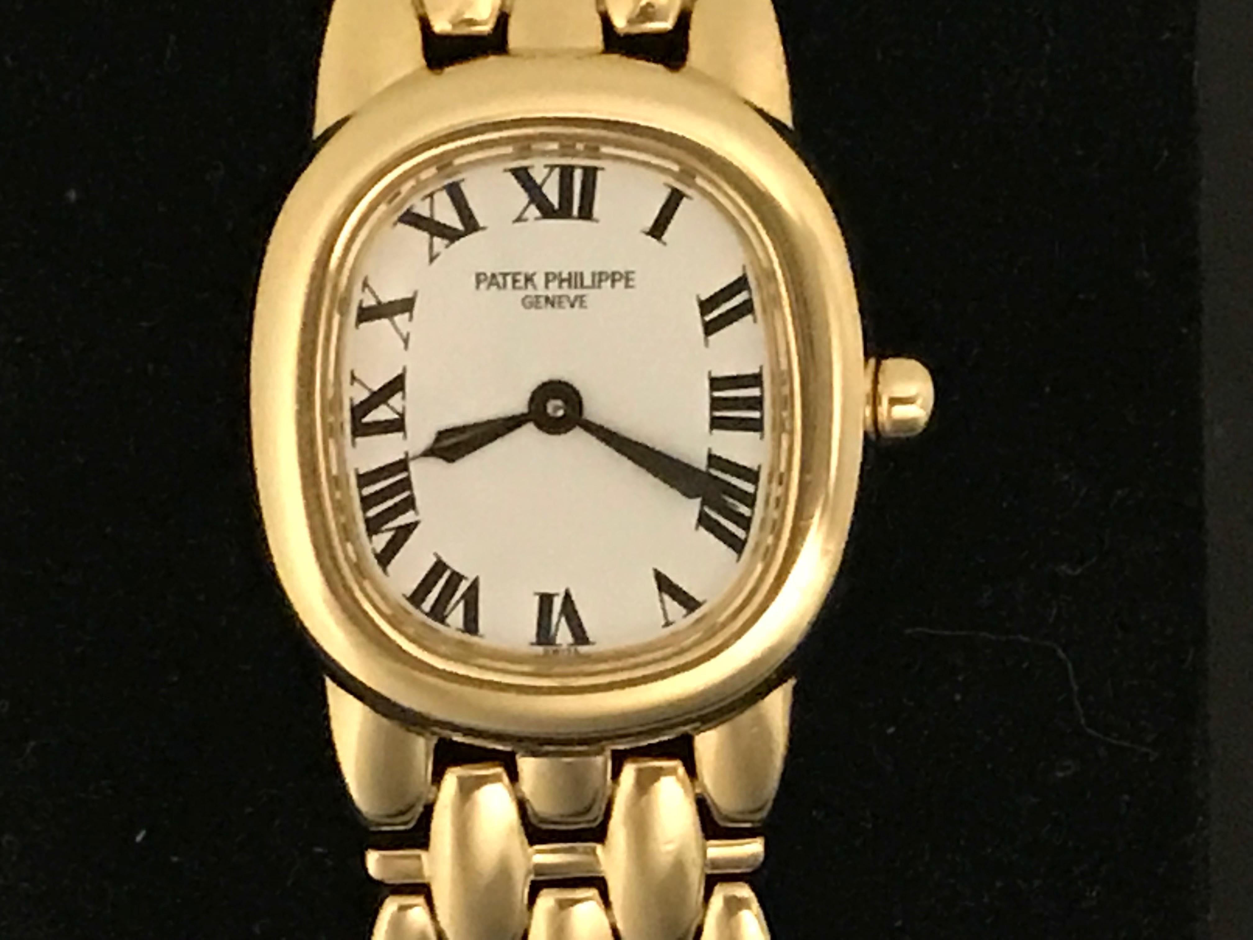 Patek Philippe Ladies 4830/001J Quartz Wrist Watch in 18K Yellow Gold.  This timepiece features an 18K Yellow Gold ellipse case, measuring 23x36mm in diameter.  White Dial with black Roman numerals. 18k Yellow Gold integrated Patek Philippe bracelet