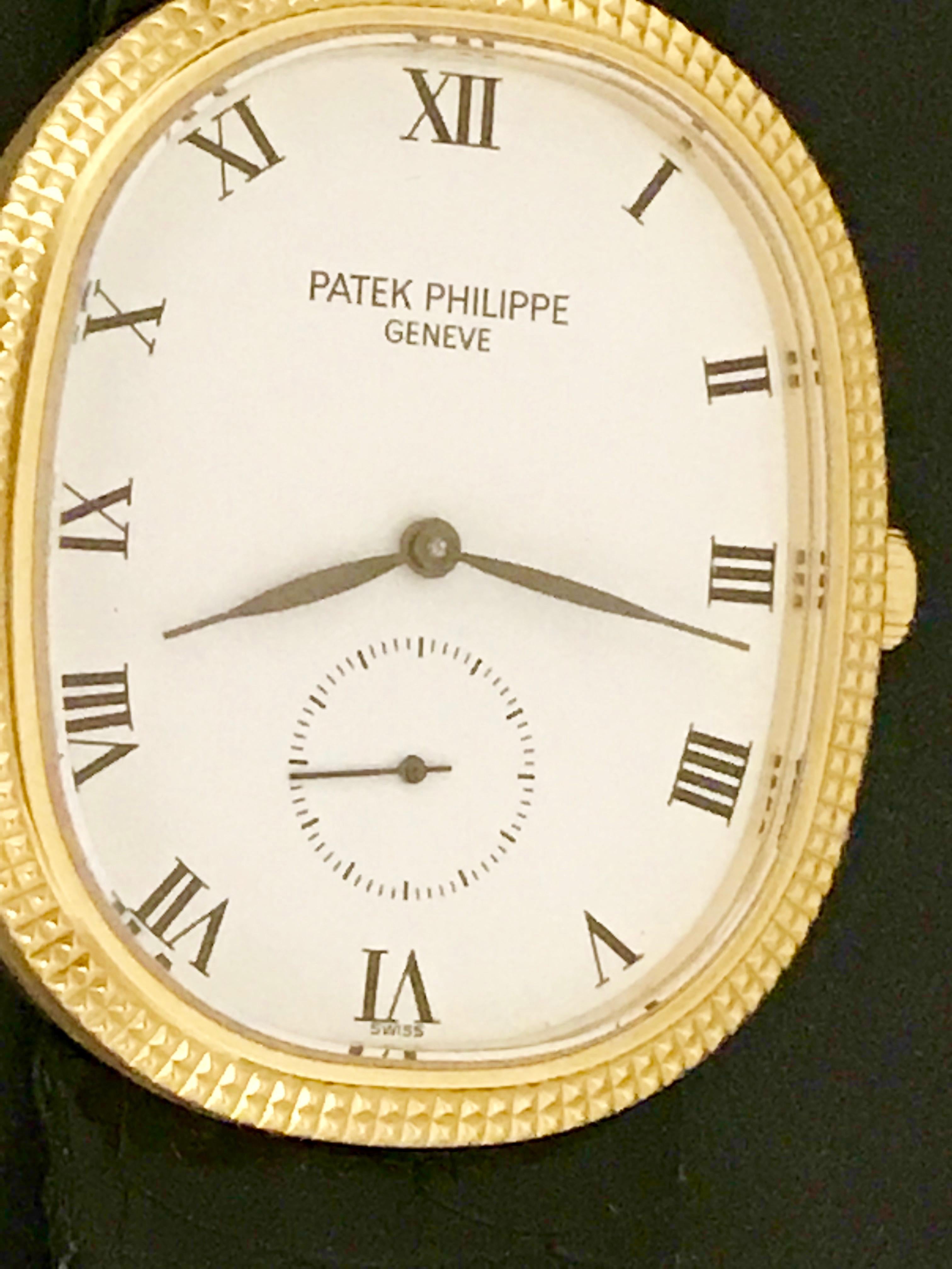 Patek Philippe Men's 3978 Manual Wind Wrist Watch in 18K Yellow Gold.  This timepiece features an 18K Yellow Gold ellipse case, measuring 27x32mm in diameter.  White Dial with black Roman numerals. Black alligator strap with 18k Yellow Gold Patek