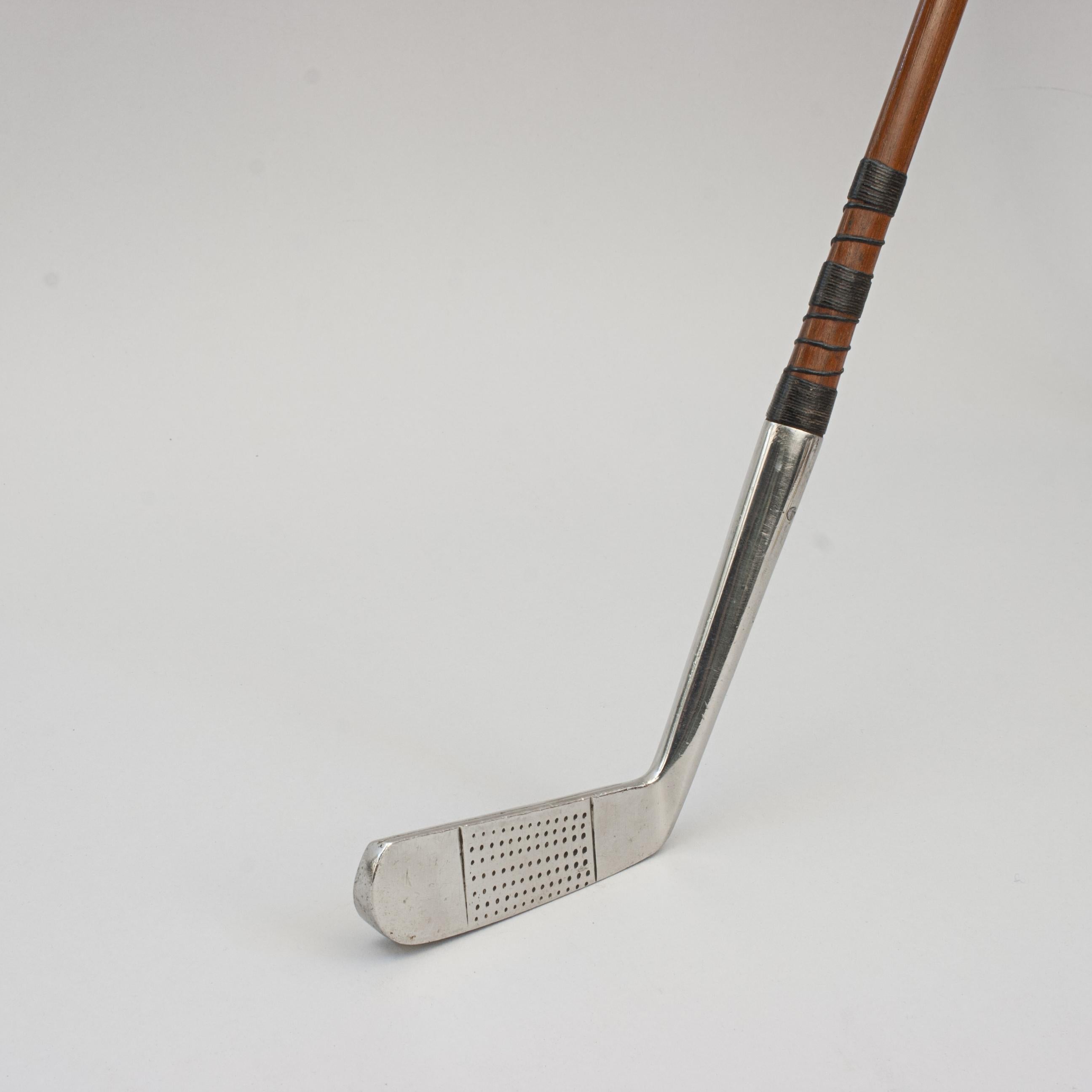 PERFECT PUTTER, M.J. Lewis.
A fine, patent blade putter with unusual ovoid shaped shaft. The shaft is made from greenheart or danga wood, is teardrop shaped with the point to the front but terminating into a square grip, all to help with alignment.