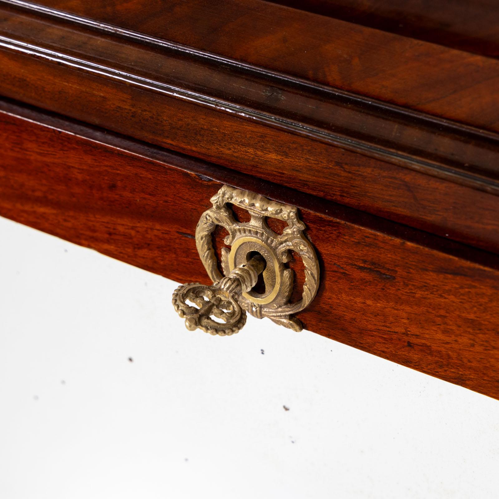 Secretaire brevettato con struttura impiallacciata in mogano e colonne con capitelli e basi in bronzo.