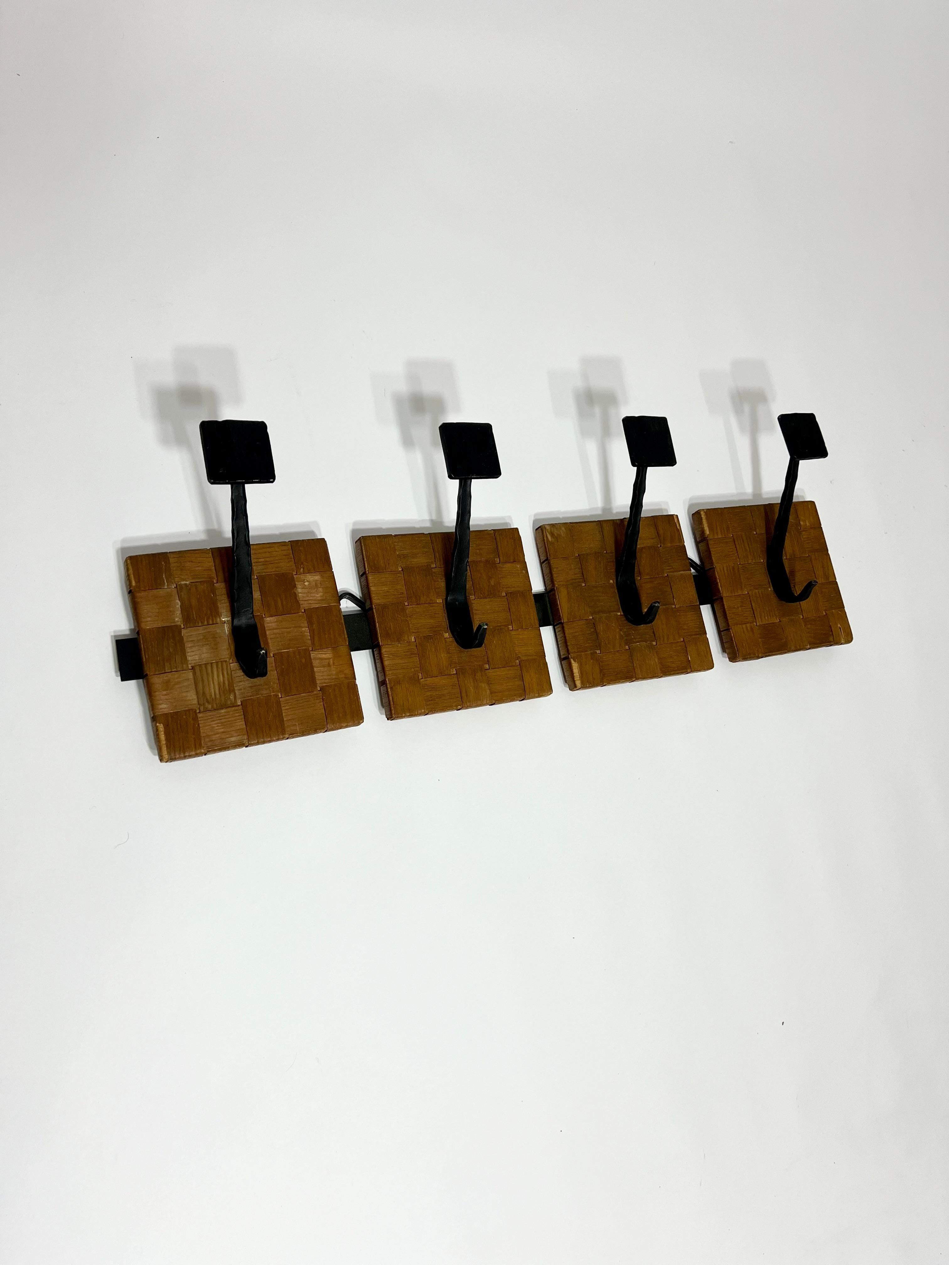 Patère en bois et fer forgé, France, années 1950-1960. Crochets en fer forgé dans le gout des Artisans de Marolles reposant sur un support métallique et sur des pièces de bois de forme carré enveloppés d'un tressage de placage de bois. Bon état
