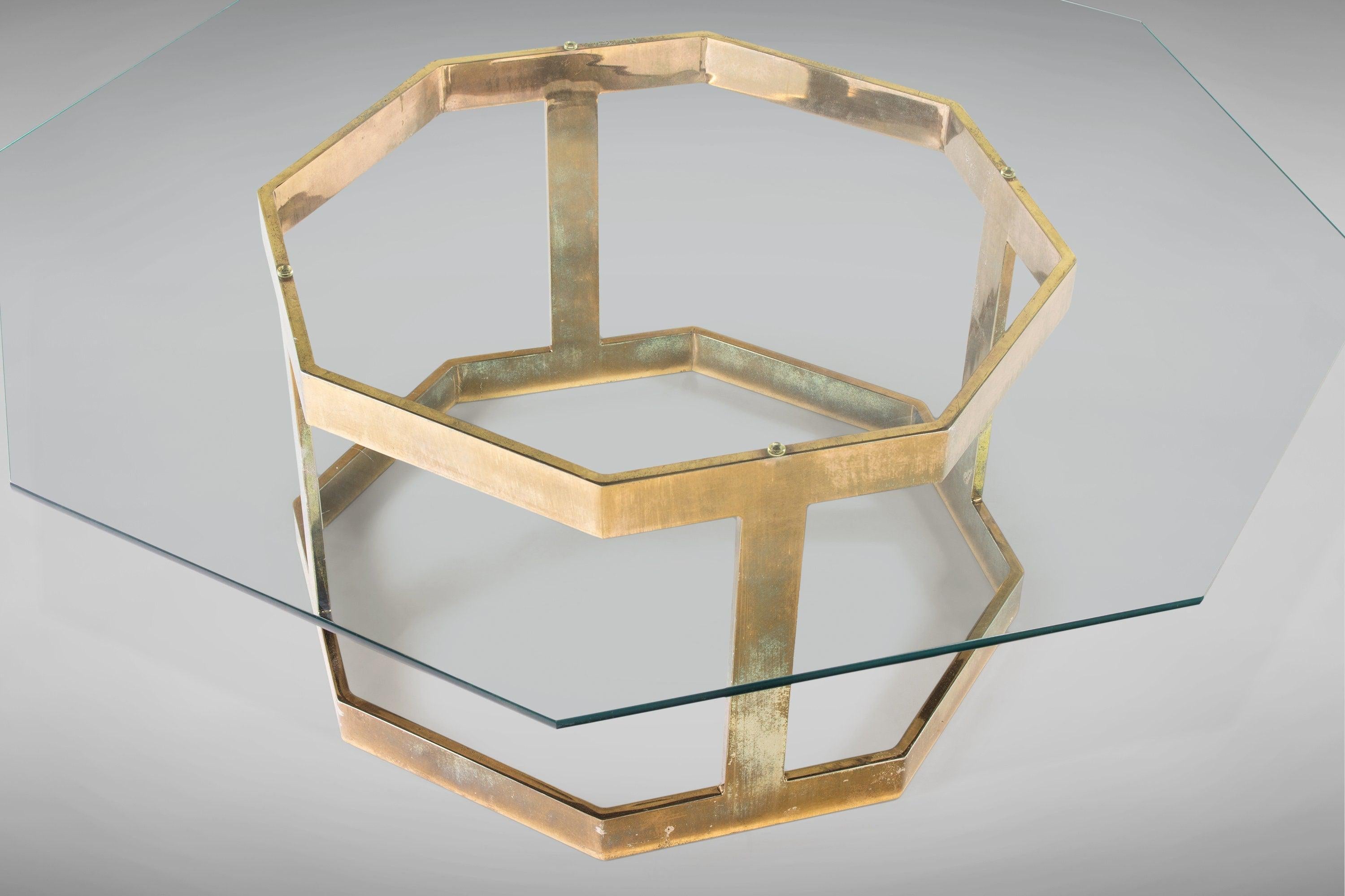 A patinaed brass base supports an octagonal glass top with a beveled edge. Interesting and eye-catching and ready for decades more of enjoyment!
