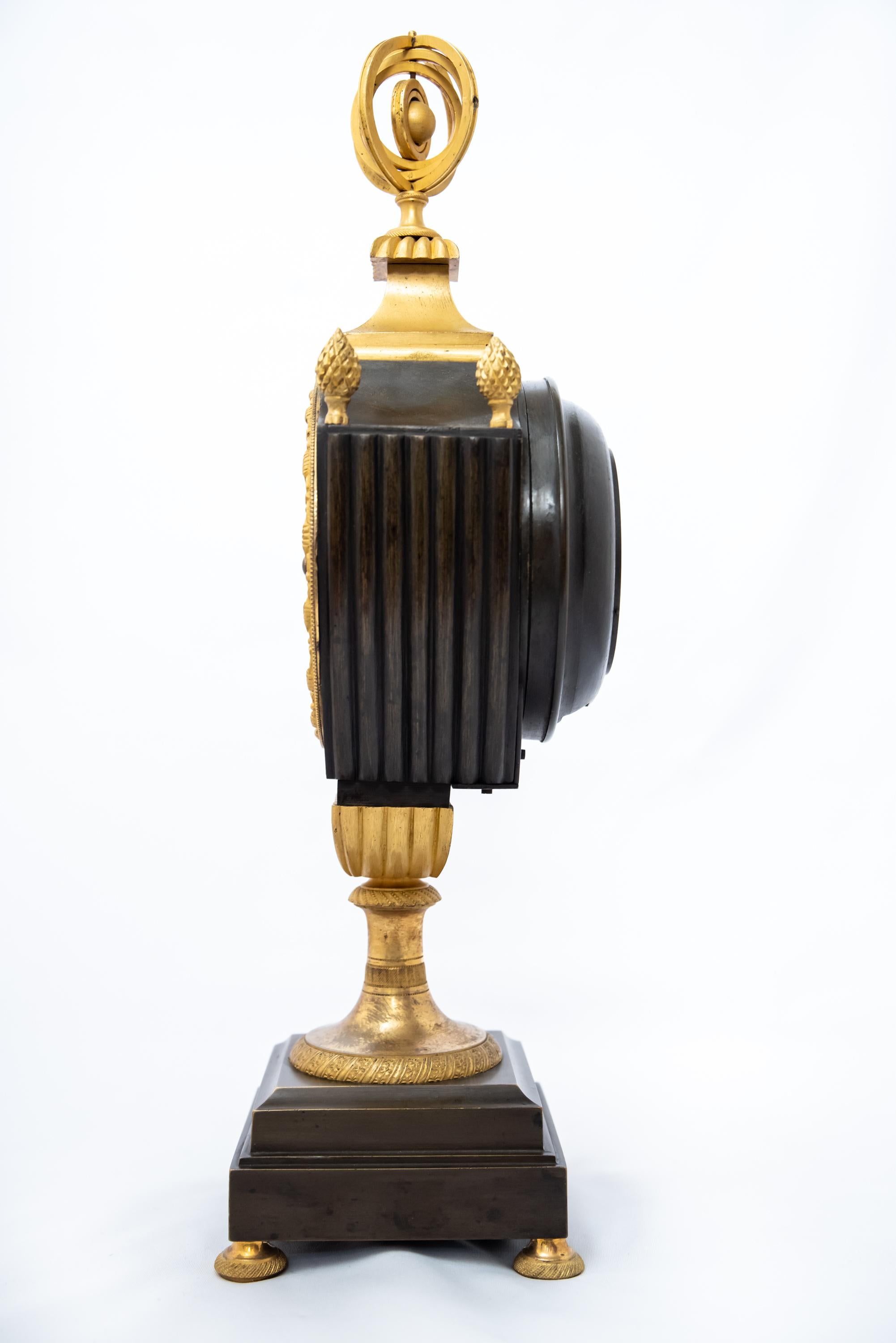 Pendule française patinée et dorée au feu en forme de vase, époque Empire, 1800-1815. Le mécanisme à fil de soie est en bon état de fonctionnement avec la clé et le pendule.