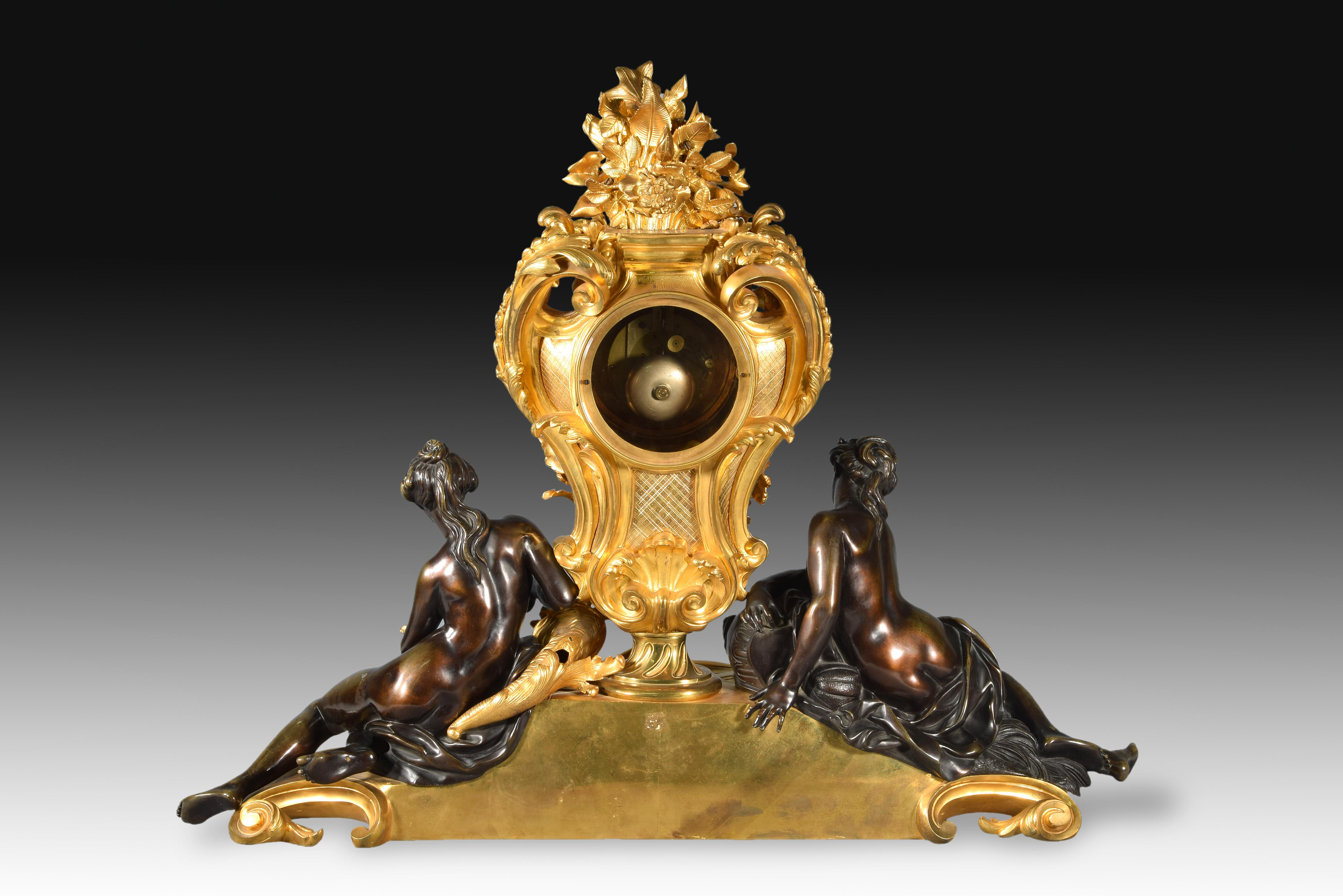 Table clock. Golden and blued bronze. Marquis, Paris, France, 19th century.
Large table clock with a blued and gilt bronze case,white dial with black Roman numerals for hours andblack Arabic numerals every five for minutes, Louis XVstyle hands and