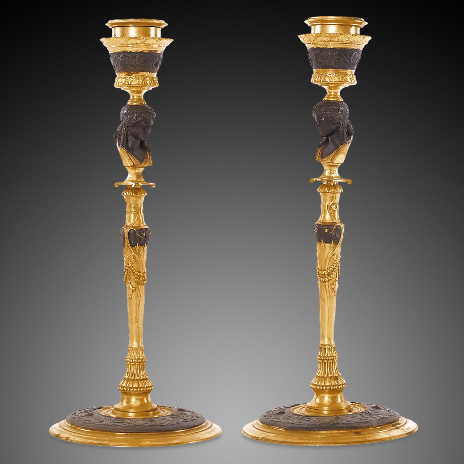 These pair of candlesticks are made from patinated bronze and finely embellished with ormolu. The base of the candlesticks are from interlocking two-layer of patinated bronze and gilded bronze circles that gives it a sturdy but refined look. The