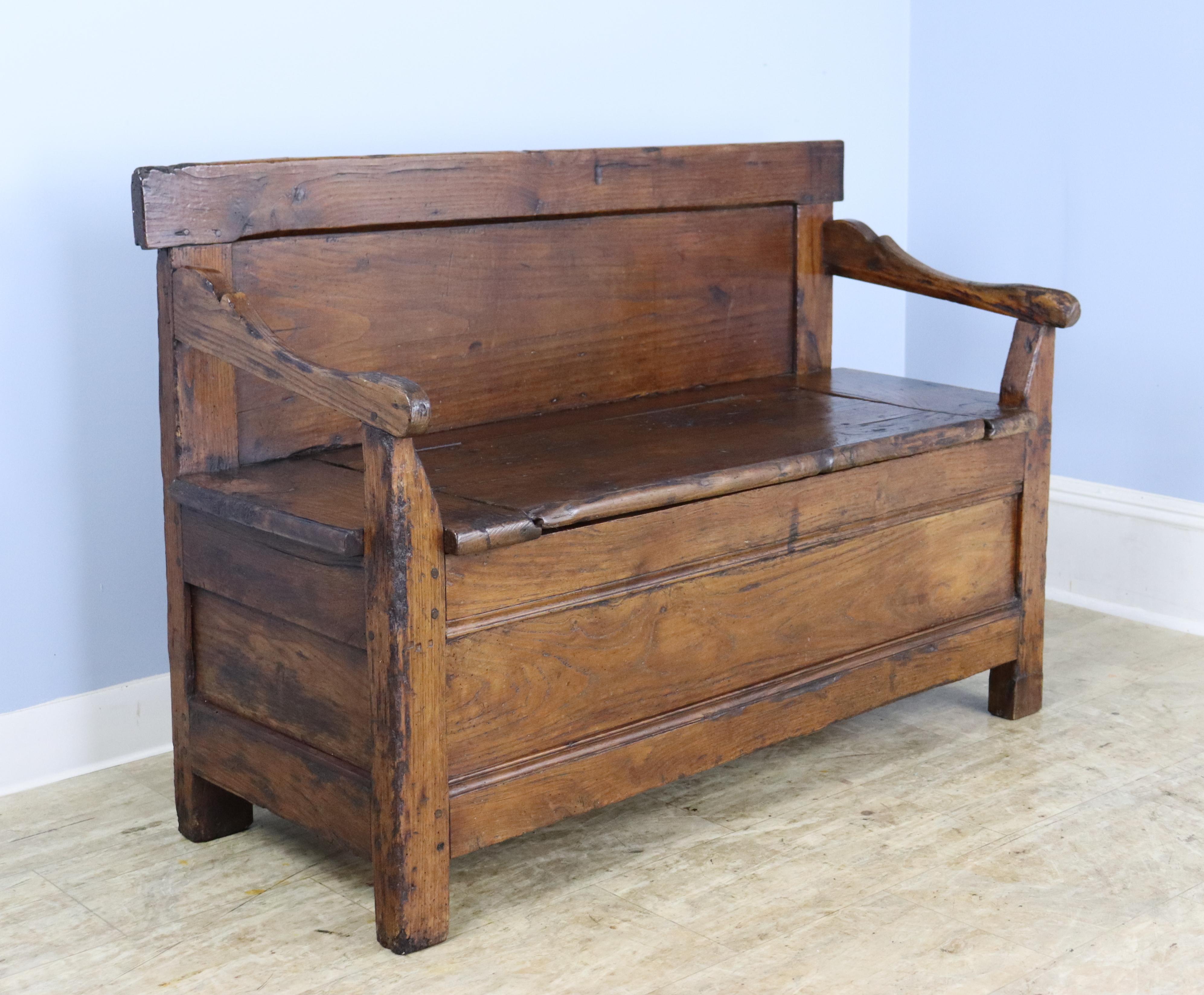 A handsome chunky chestnut bench with lots of good wear and a hinged flip up seat with good storage.  The interior of the storage compartment is quite clean.
