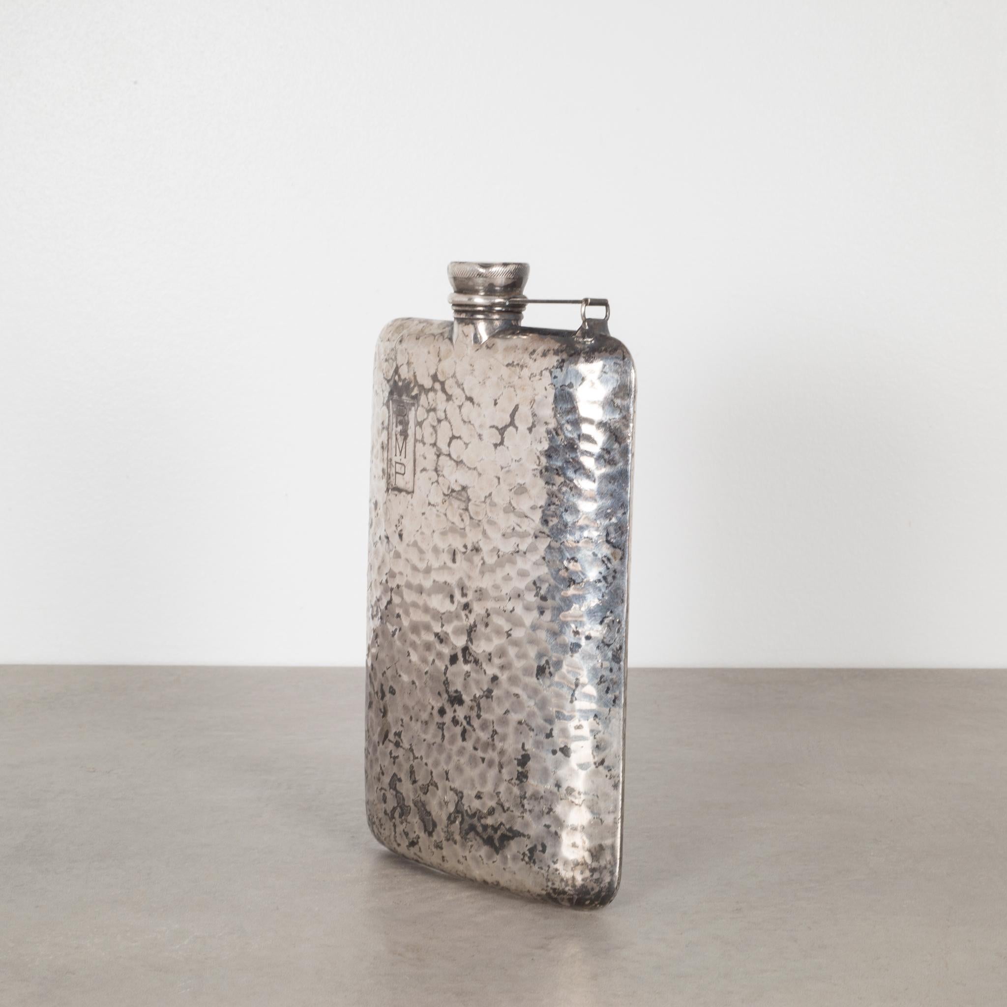 About

This is an original hammered silver plated flask by Apollo Silver Company. This large flask has a flip top with a cork interior. The company's logo is stamped inside the flip top and 