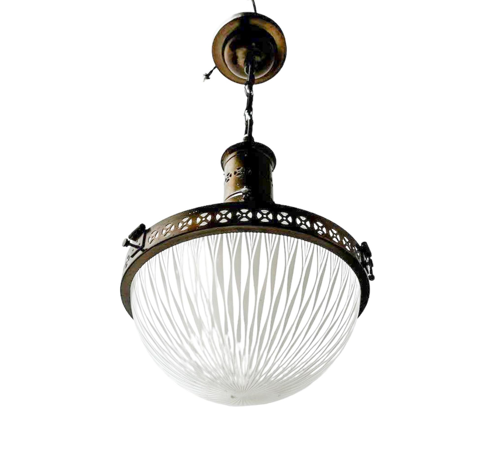 Stunning and elegant Arts & Crafts pendant light.
Design by Holophane.
Striking English design from the 1900s.
Original patinated brass holder and canopy with the original patinated brass chain.
Original prismatic glass and straight lined glass