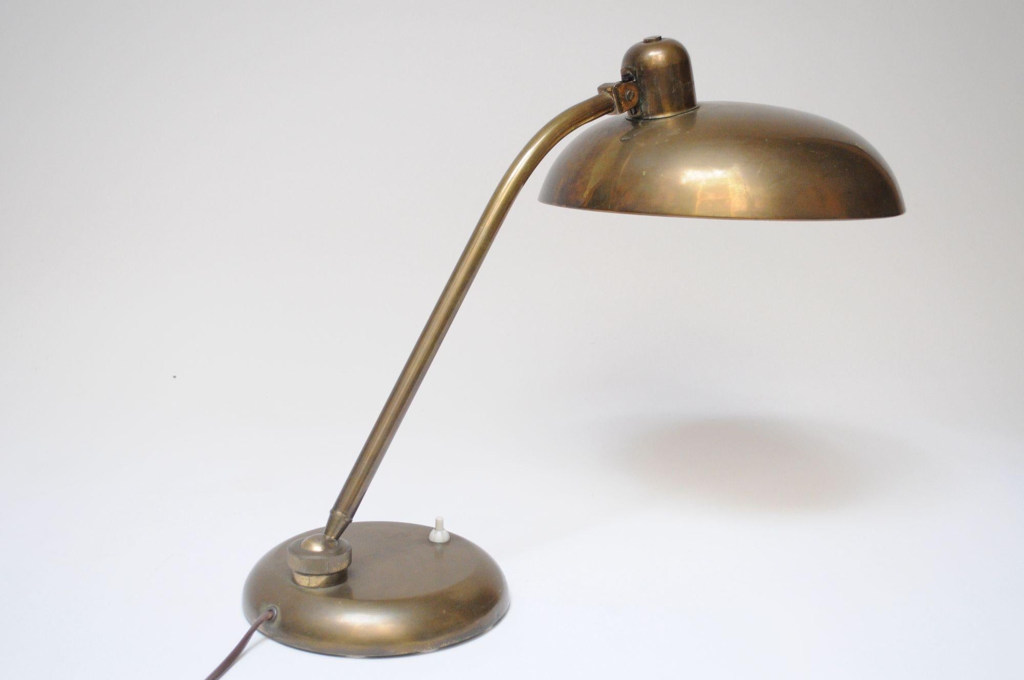 Lampada ministeriale in ottone patinato di Giovanni Michelucci per Lariolux (1940 circa, Italia).
Composto da un ampio paralume regolabile sostenuto da uno stelo girevole e da una base rotonda.
Condizioni originali, non lucidate, con patina