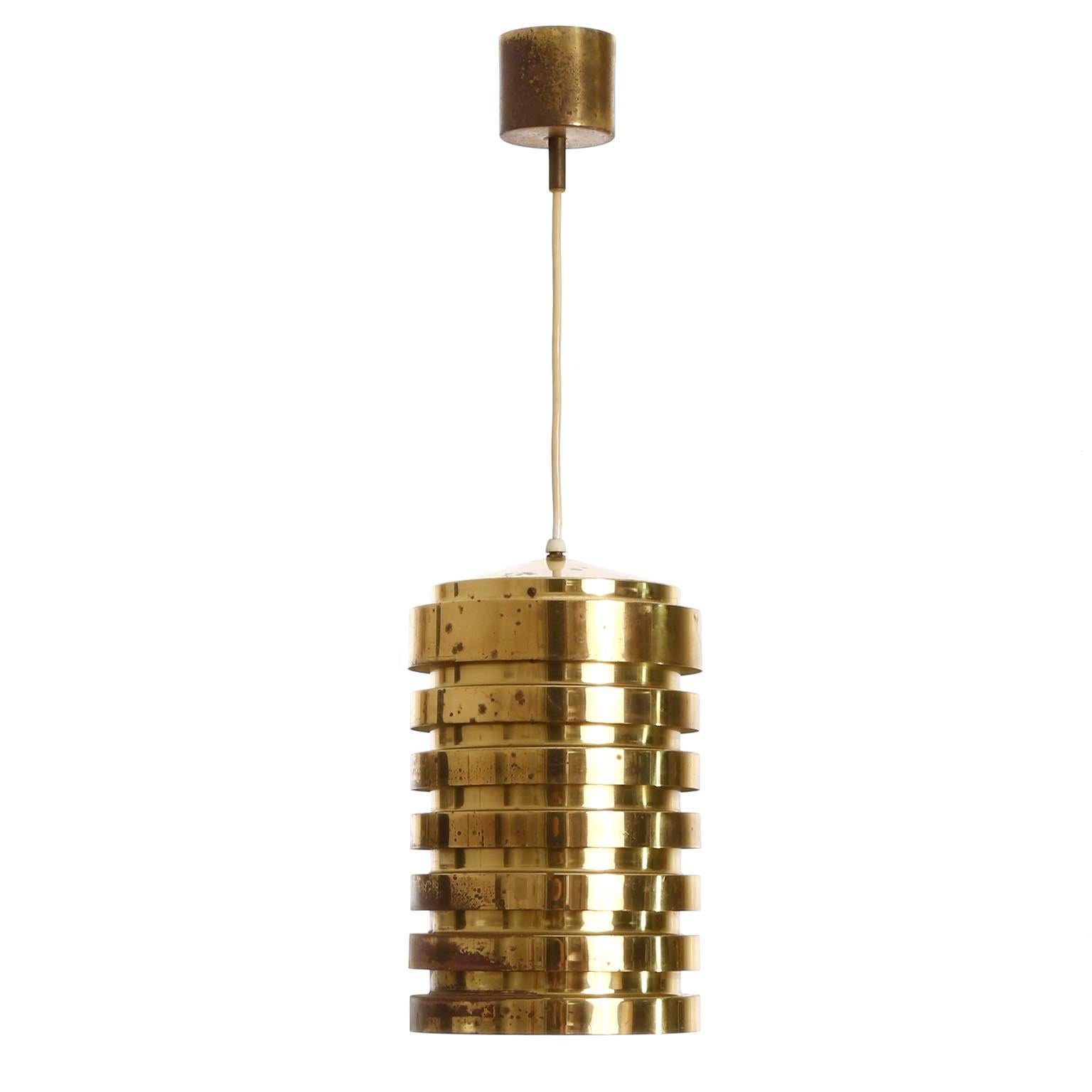 A Mid-Century Modern cylindrical and polished solid brass pendant light with great patina designed by Hans-Agne Jakobsson and manufactured by AB Markaryd circa 1960.
The inside is painted white, aged and thus a bit yellowed.
One side has more patina