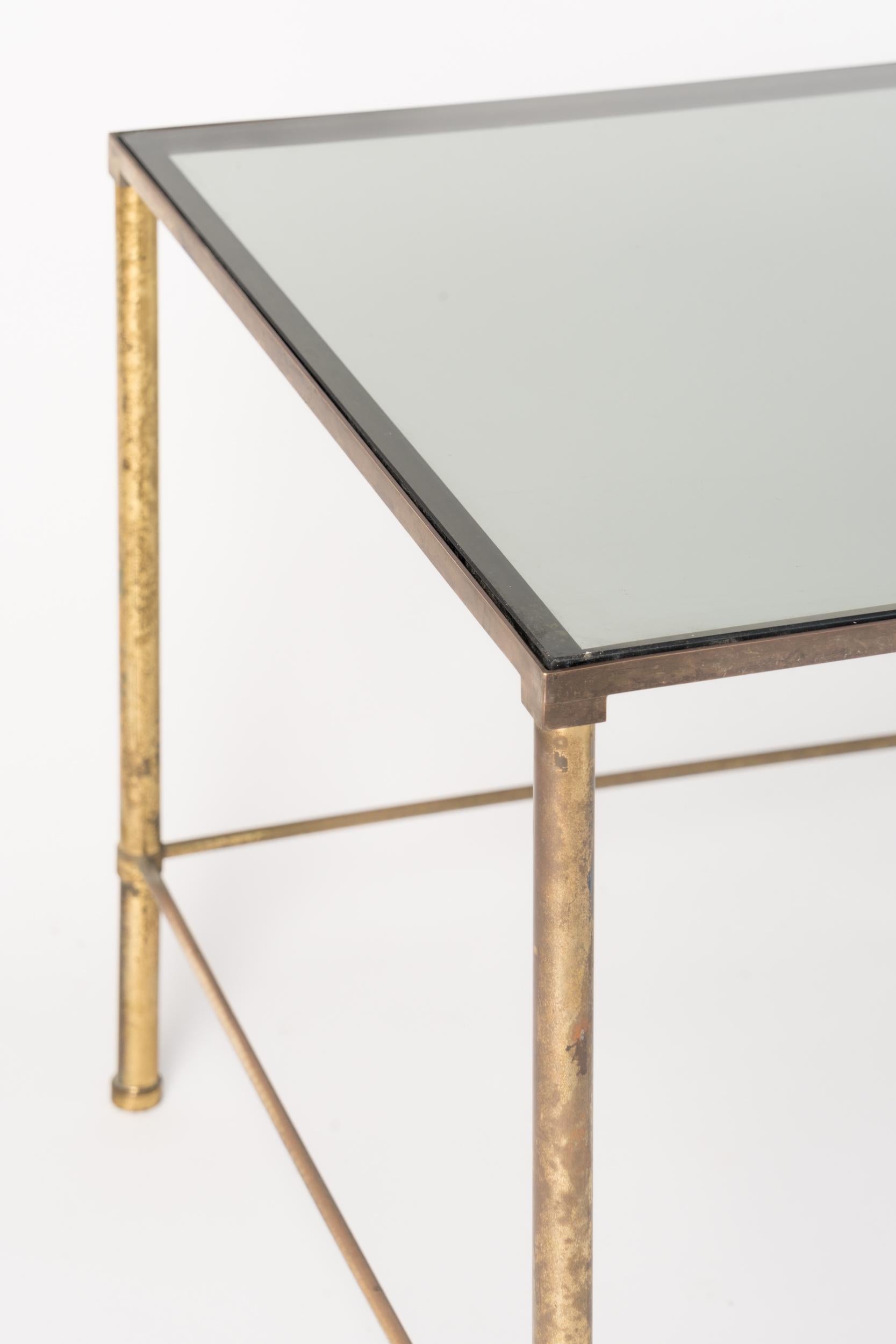 Elegant tubular feet brass table with a great patina. Smoked glass top. 
Italy 1970's.
This piece wlll ship from France and can be returned to either France or to a LIC NY location.
Price does not include shipping nor possible customs duties