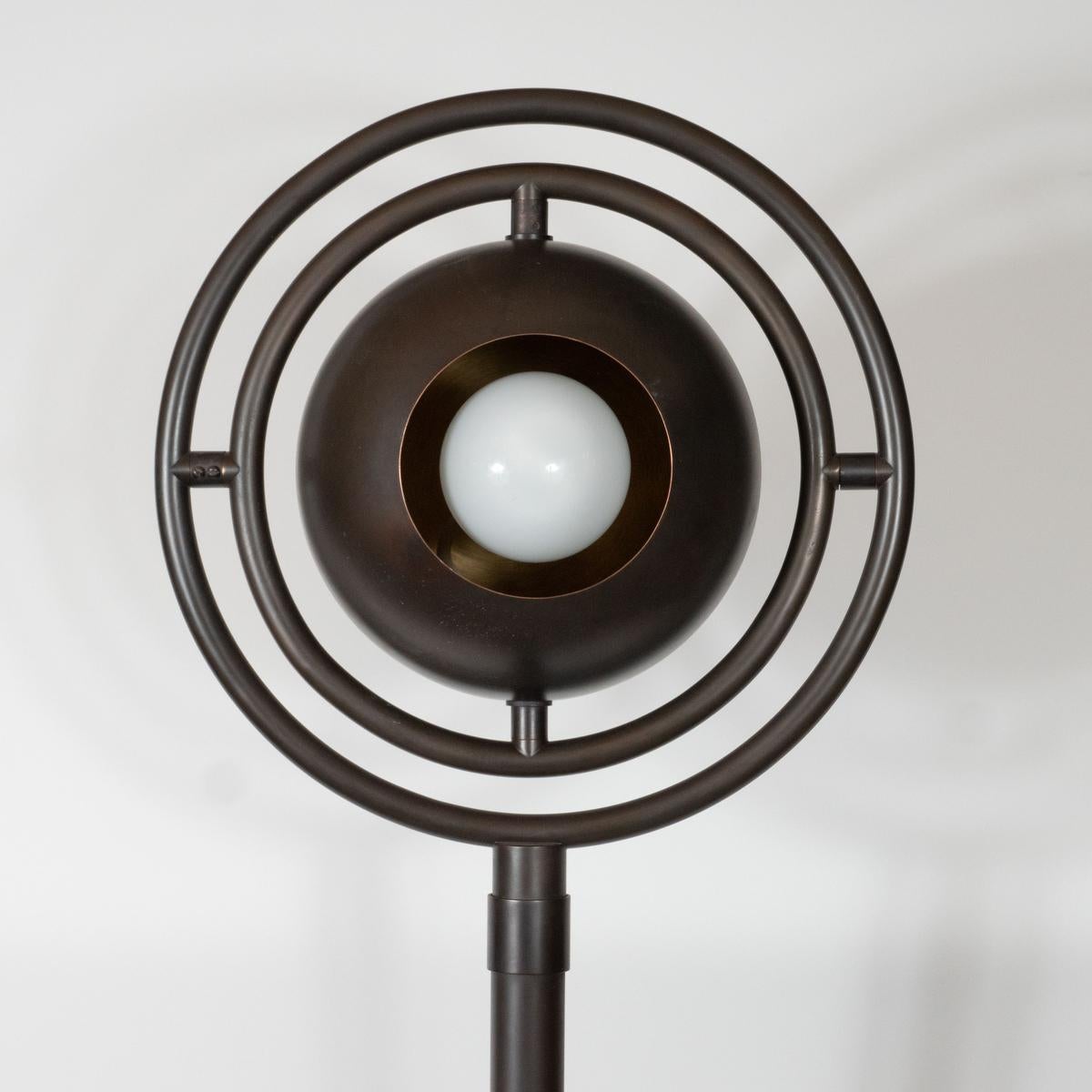Space Age, patinated brass floor lamp with adjustable orbital shade.