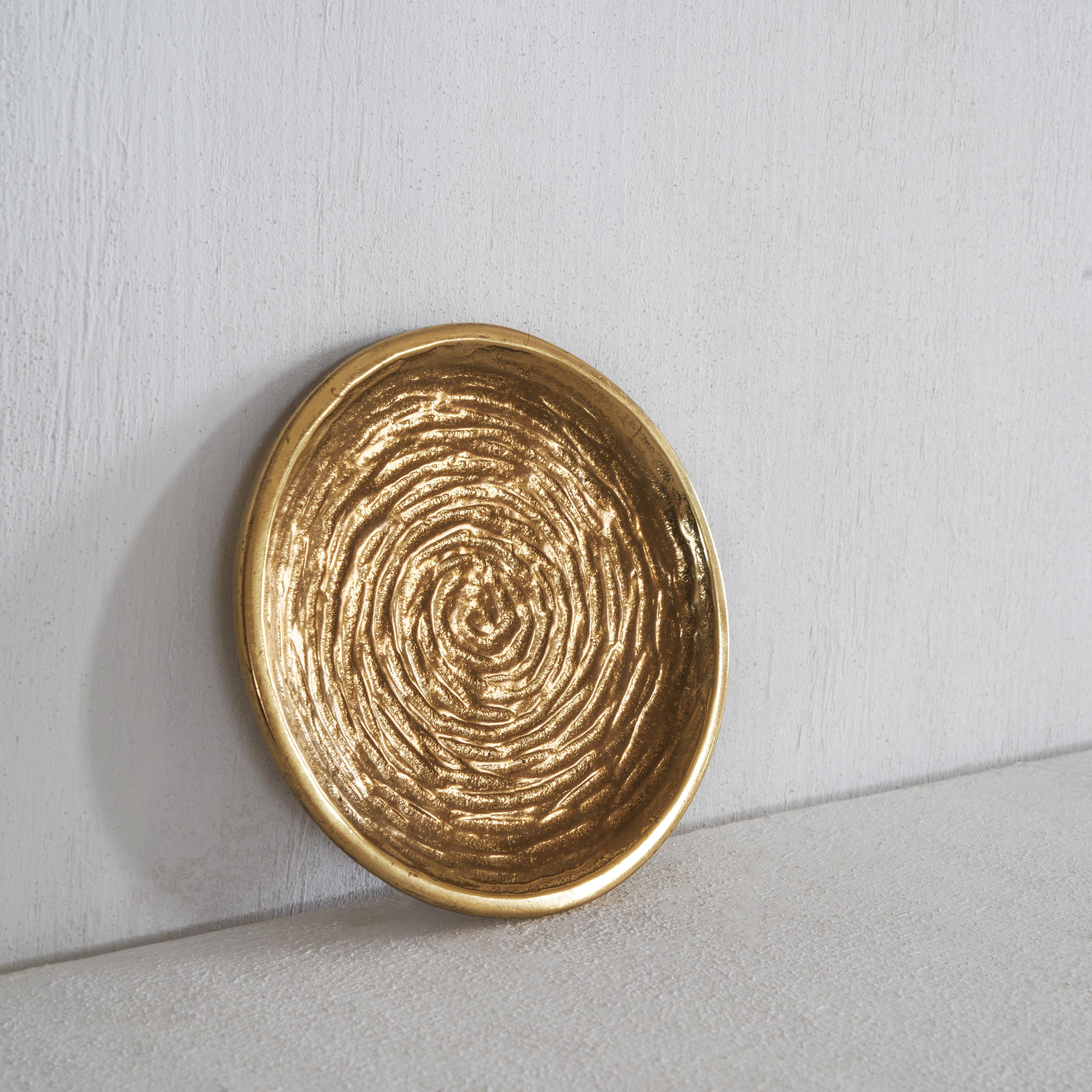 Set of three plates in beautifully patinated brass. The design is reminiscent of a water drop hitting the water surface, leaving a pattern of ripples. You can lose yourself in the details of these special plates. Combined together in the middle of a