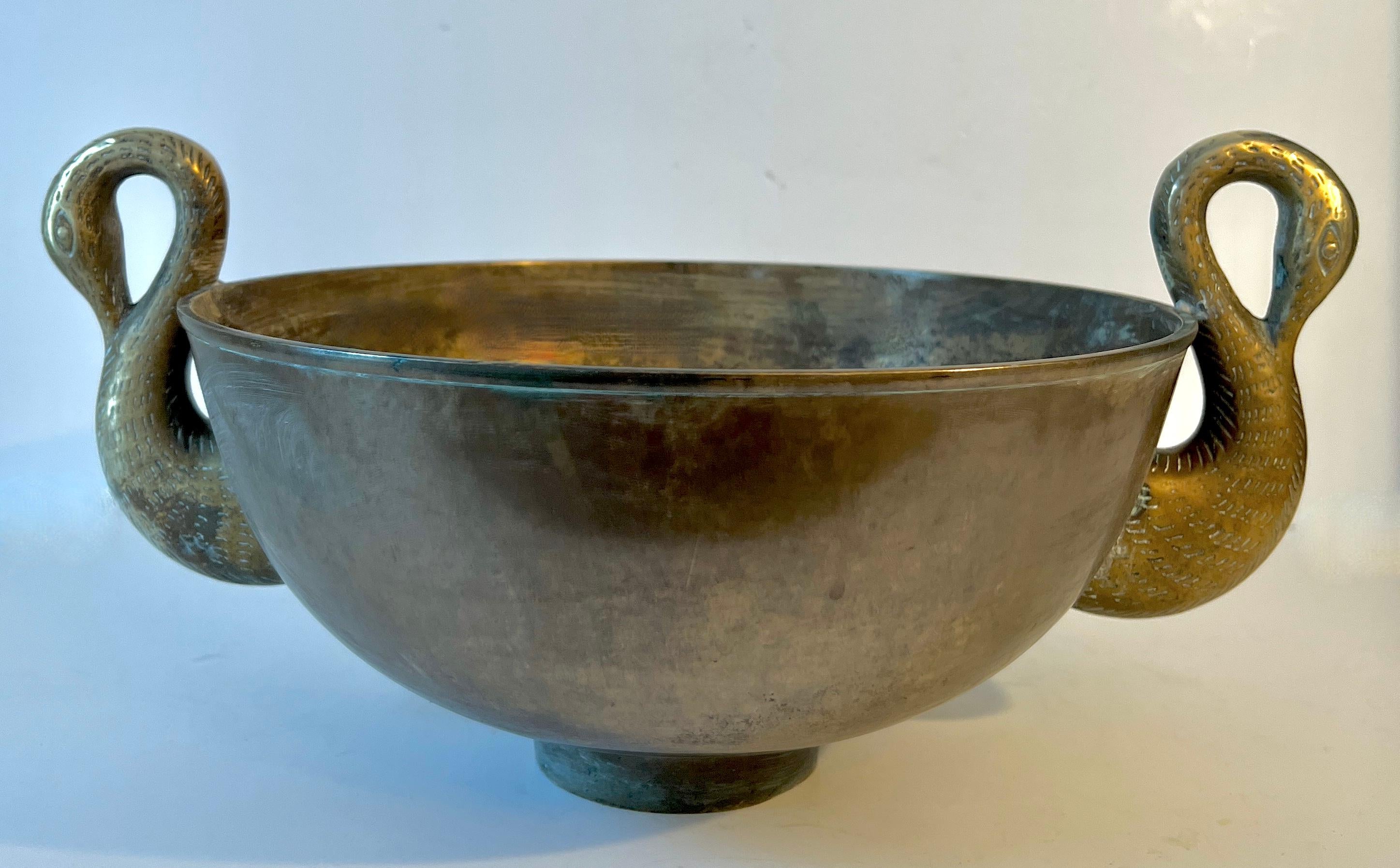 Très lourde coupe en bronze de style Art déco français reposant sur un petit pied cylindrique avec des poignées en forme de cygne de chaque côté.

Le bol parfait pour créer un centre de table, contenir de la glace pour le champagne, faire pousser