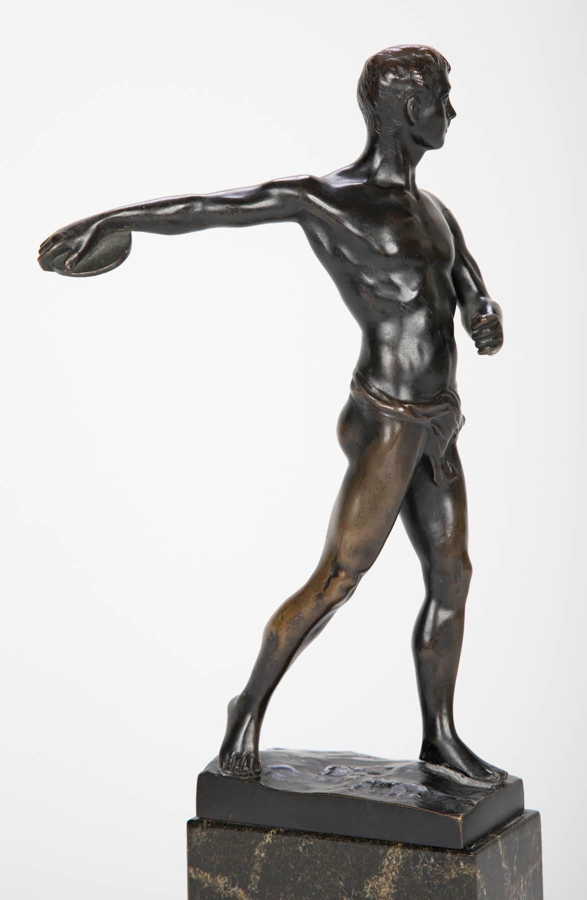 Patinated bronze figure of a discus thrower mounted on a marble base.