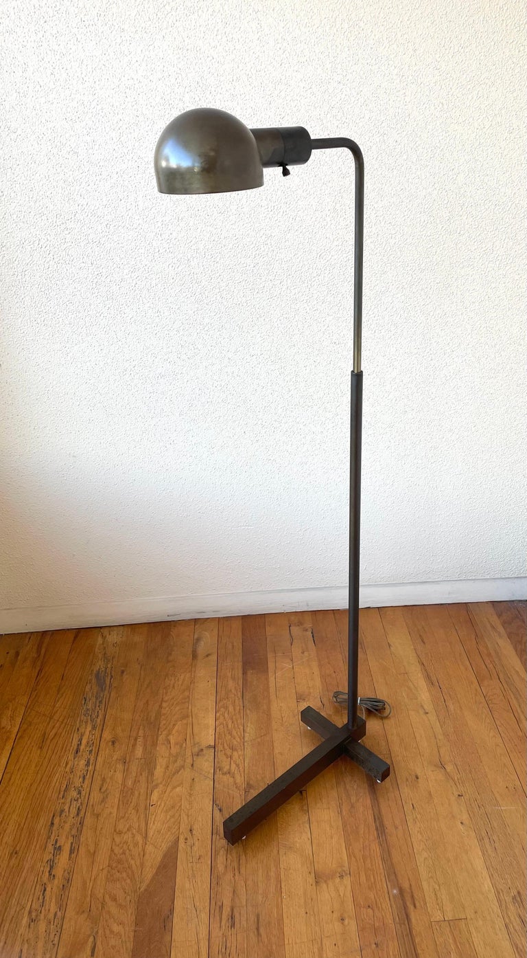 Very unique brass floor lamp by the renowned San Francisco lighting company, Casella Lighting. The lamp has a bronze patinated finish that can be polished if desired. The height is adjustable from 39