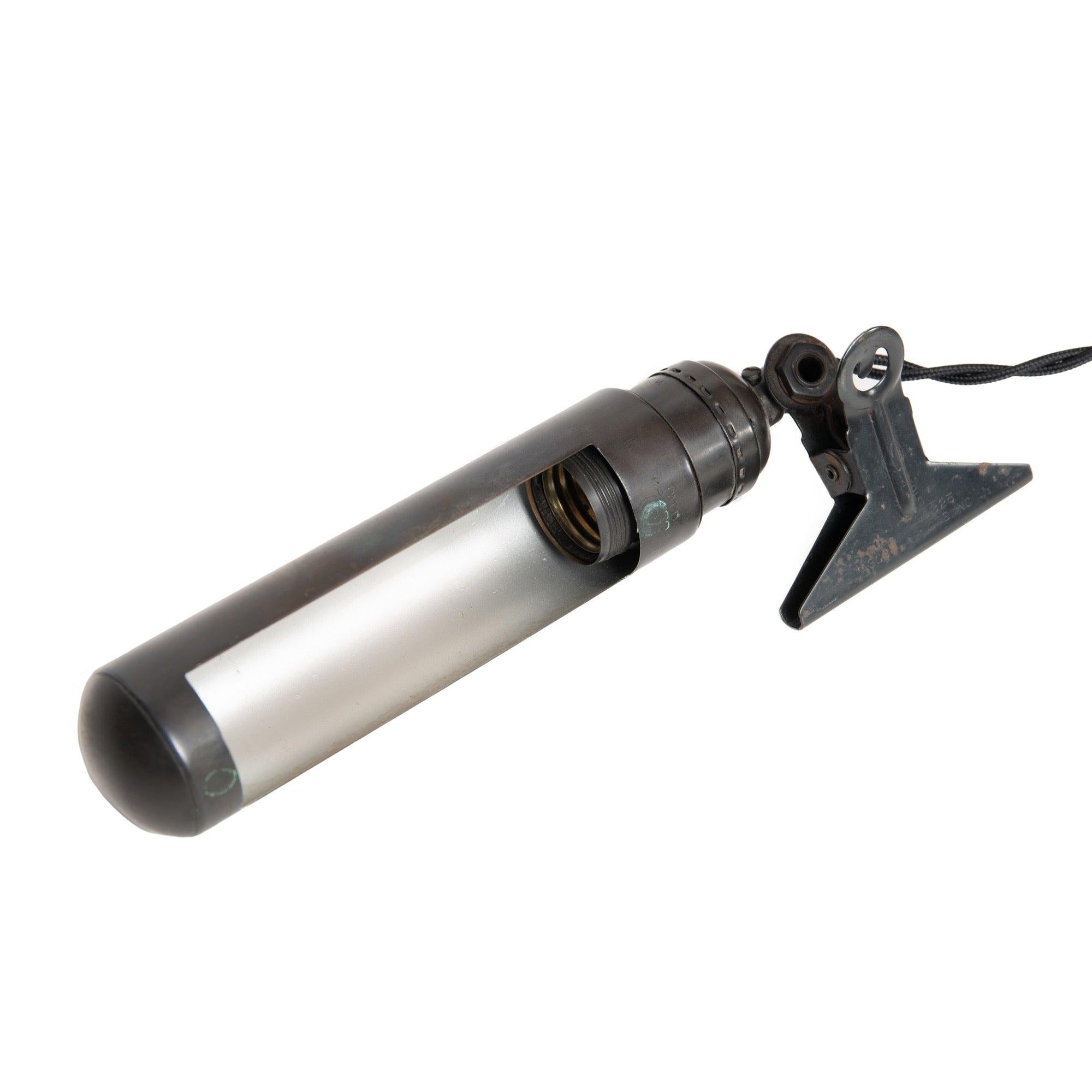 Lampe de travail tubulaire avec clip de fixation intégré et charnière pivotante. Refini en patine noire et recâblé par l'Atelier.